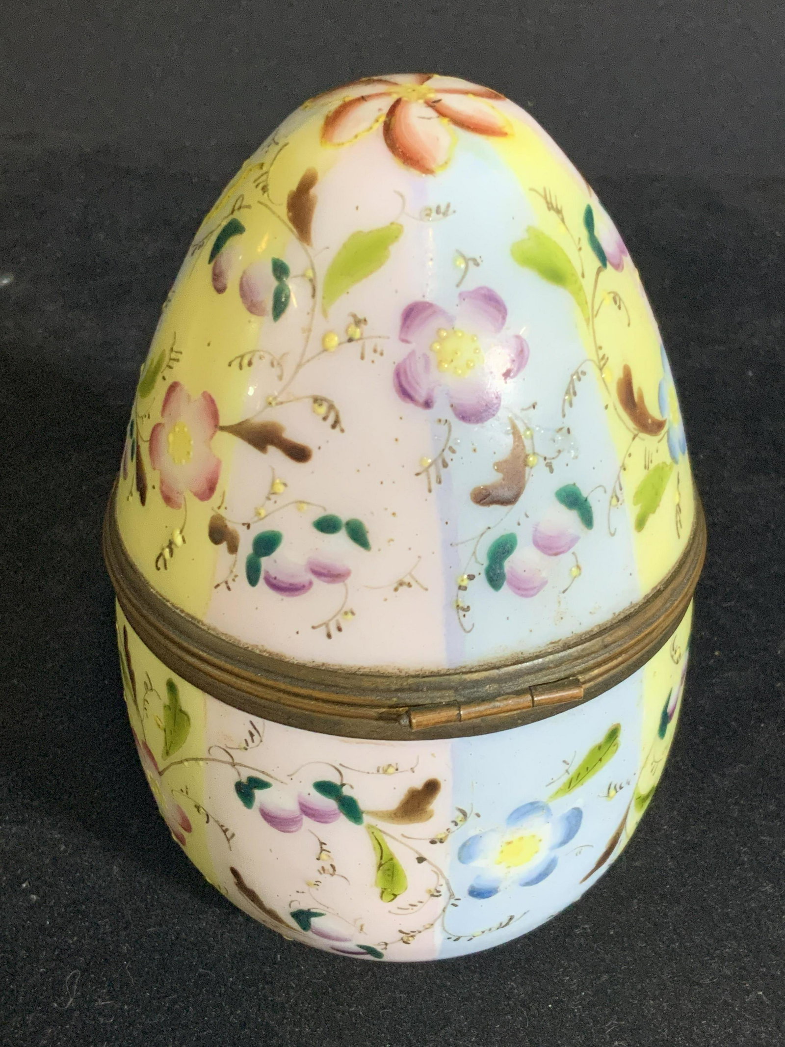Vintg. Hand Painted Porcelain Egg Form Pill Box: A striped porcelain egg shaped trinket box. Stripes are painted yellow, blue, and pink. Throughout striped design are hand painted floral motifs with gilt line work. Yellow hues in relief accents are 