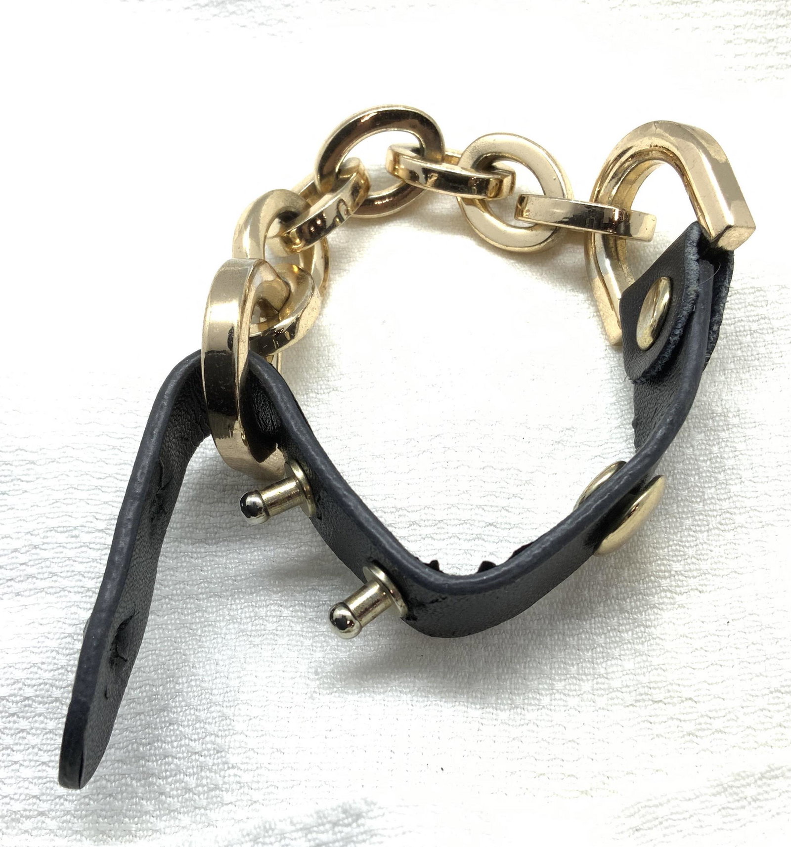 Leather and Gold Tn Link Chain Bracelet, Jewelry: fashion jewelry. Leather fits into metal pegs to open/ close. Polished gold tone metal links flanked by horseshoe shaped hardware. App 8 in. Leather and metal fashion jewelry, Ladies Bracelet, Ladies 