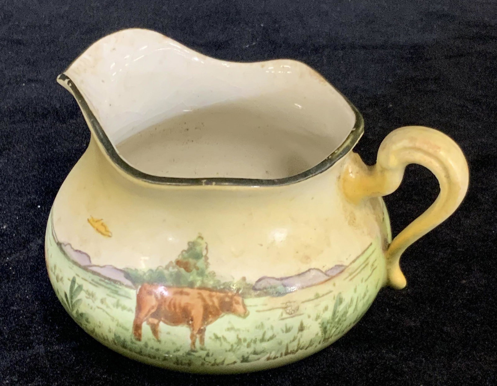 CLOVERDALE Sig. Haynes Ware Hand Painted Creamer: A vintage ceramic creamer with a hand painted farm scene. One brown cow stands alone in a lush pasture. Mountains in the background. Elephant ear handle. Scalloped mouth. Underside reads: Cloverdale, 