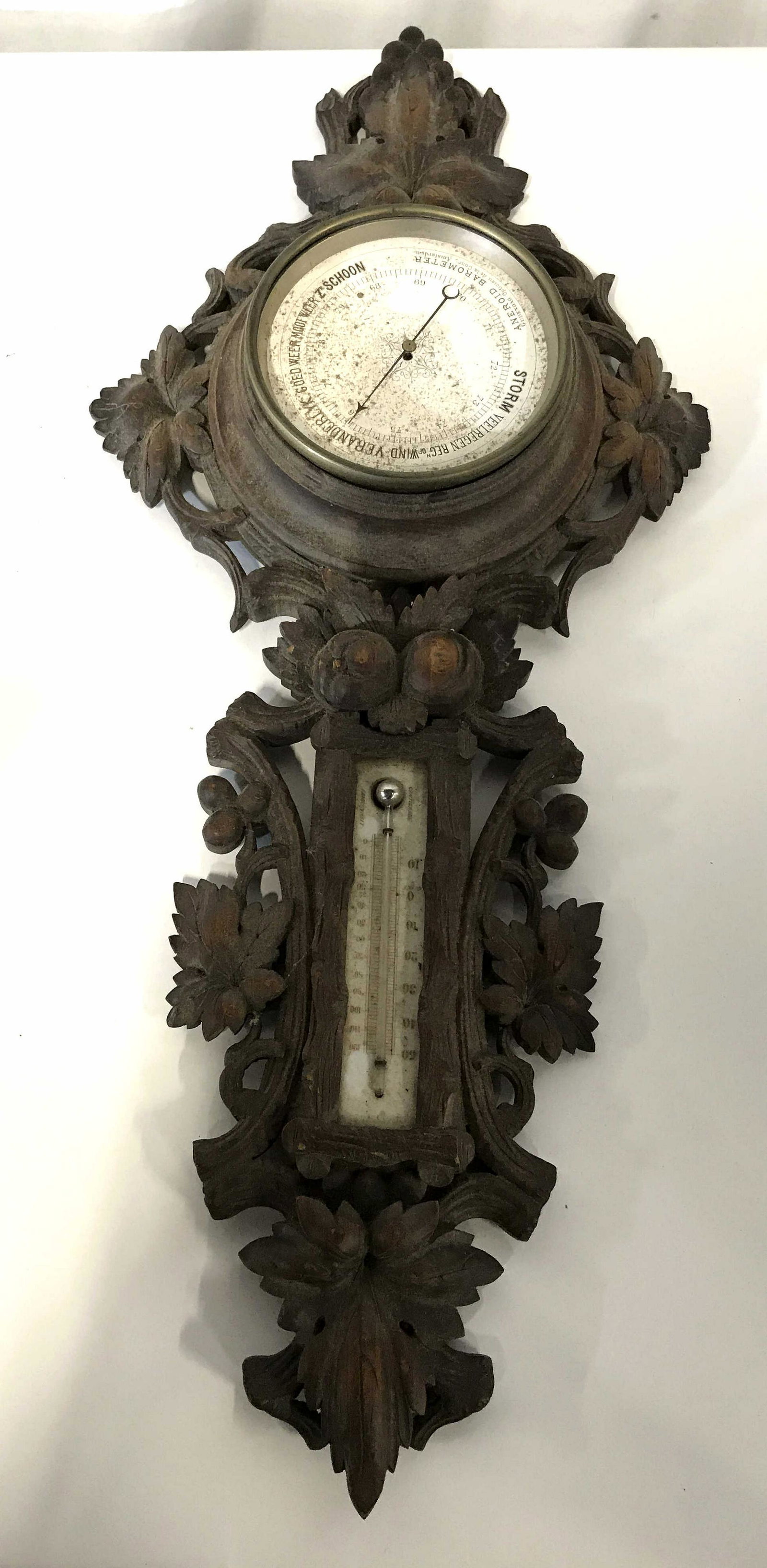 Aneroid Wooden Barometer & Thermometer: Aneroid wooden barometer, body of piece is made of wood and carved with leaf and floral designs, thermometer can be seen to the bottom section with both Fahrenheit and Celsius, barometer, text to face