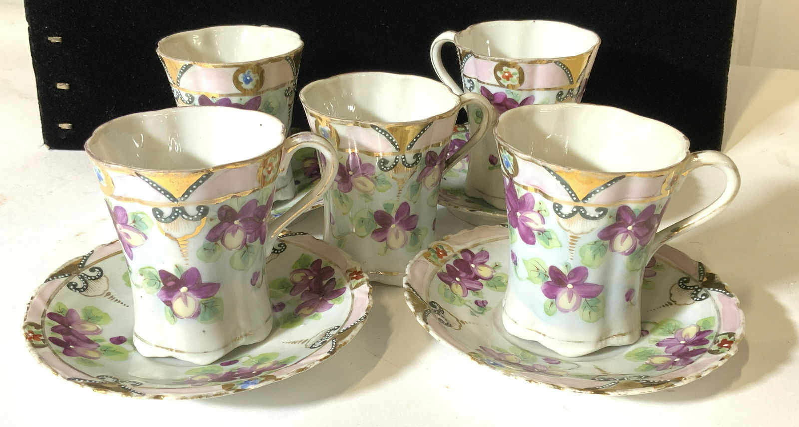 Set 9 HAND PAINTED Porcelain Demitasse Set: Fine Bone translucent China , not trademarked, hand painted within purple flowers. Cups measure 3 in tall, 3.5 in wide. Saucer Measure 5 in. 5 cups, 4 saucers. Victorianware porcelain demitasse cups a