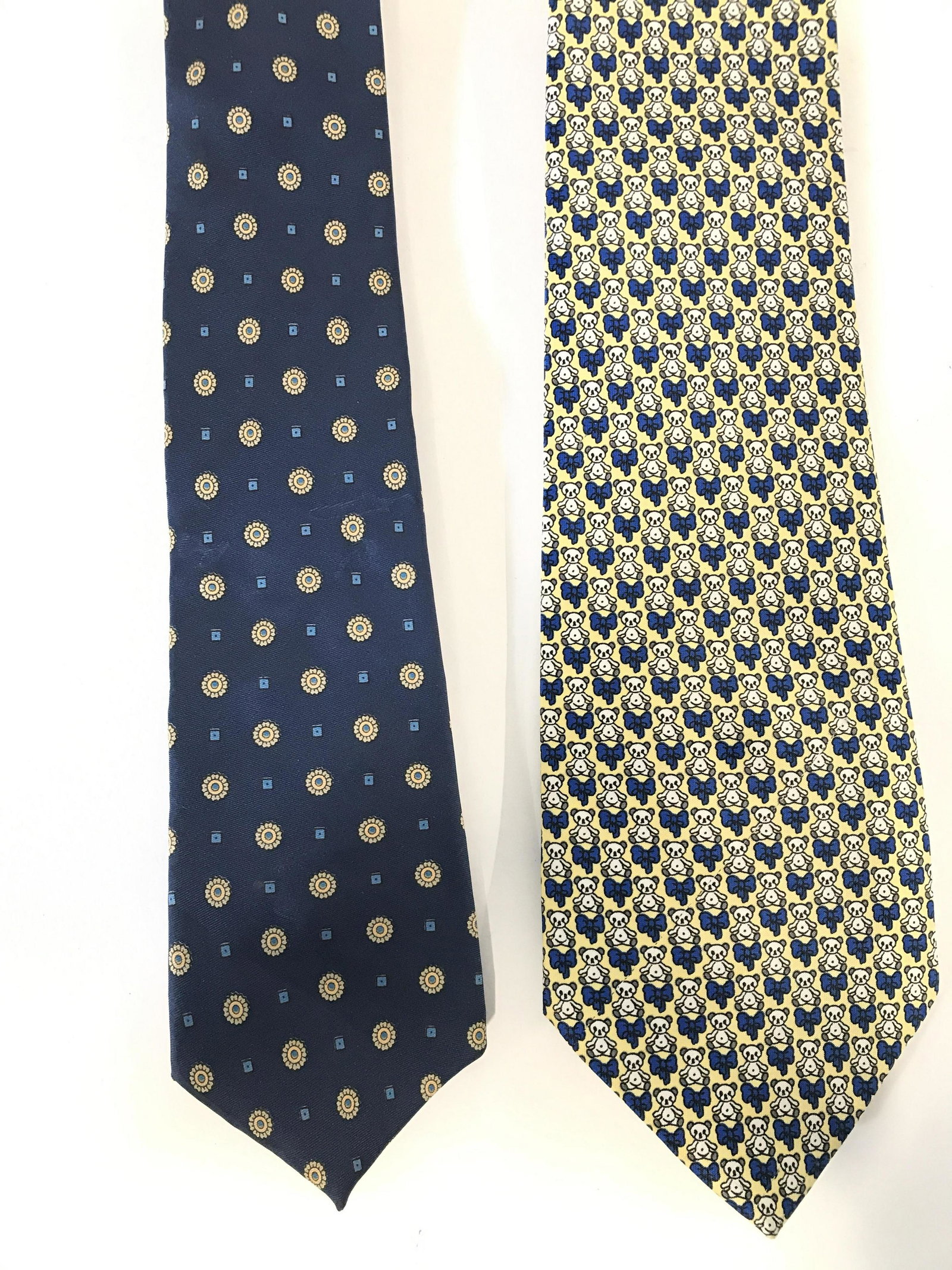 Lot 2 EVERYDAY & GEORGE GIBSONS Neckties: Lot includes 2 neckties. One tie has tag which reads EVERYDAY, the other reads GEORGE GIBSONS. One has tones of navy, blue, gold & slate with geometric detail the other is blue yellow & white toned to