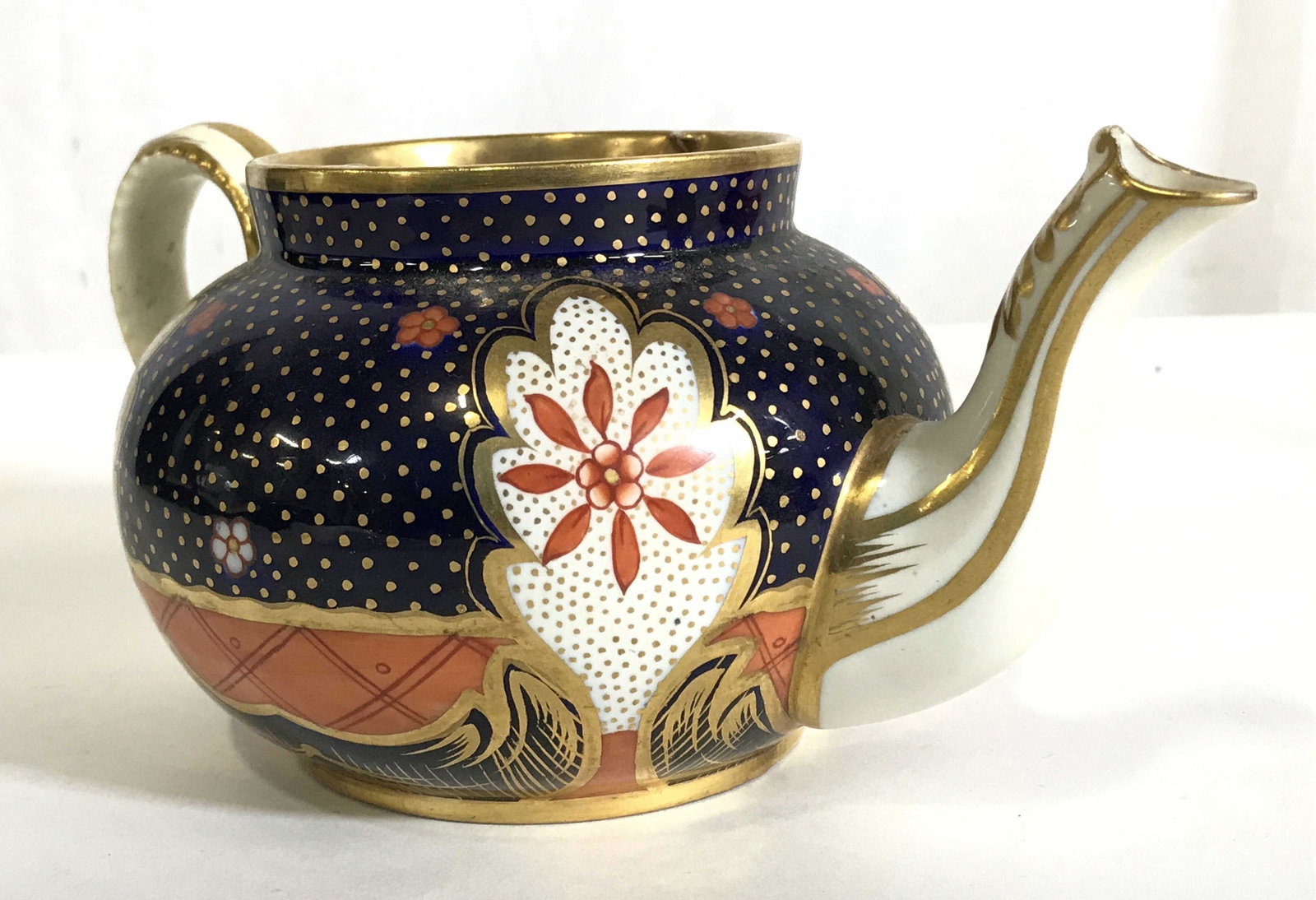 TIFFANY & CO Porcelain Teapot: Underside is marked TIFFANY & CO NEW YORK MADE IN ENGLAND. Teapot is porcelain. Piece is intricately detailed with multi toned floral, leaf and geometric detail. Piece measures approximately 8 inches 