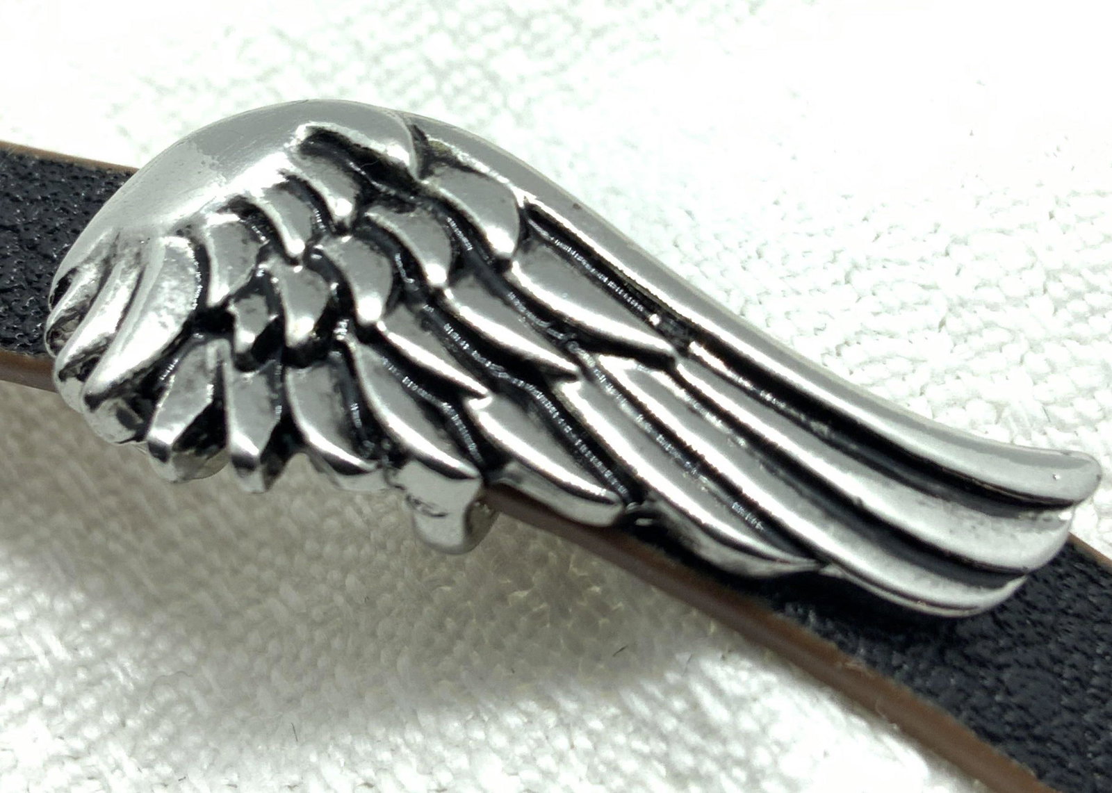 Leather Style Putti Wing Choker Necklace, Jewelry: Black faux leather putti wing choker style necklace. Putti wing is etched silver tone metal. Belt buckle style closure can be used to adjust length of choker. Underside of choker is brown. Approx. Len