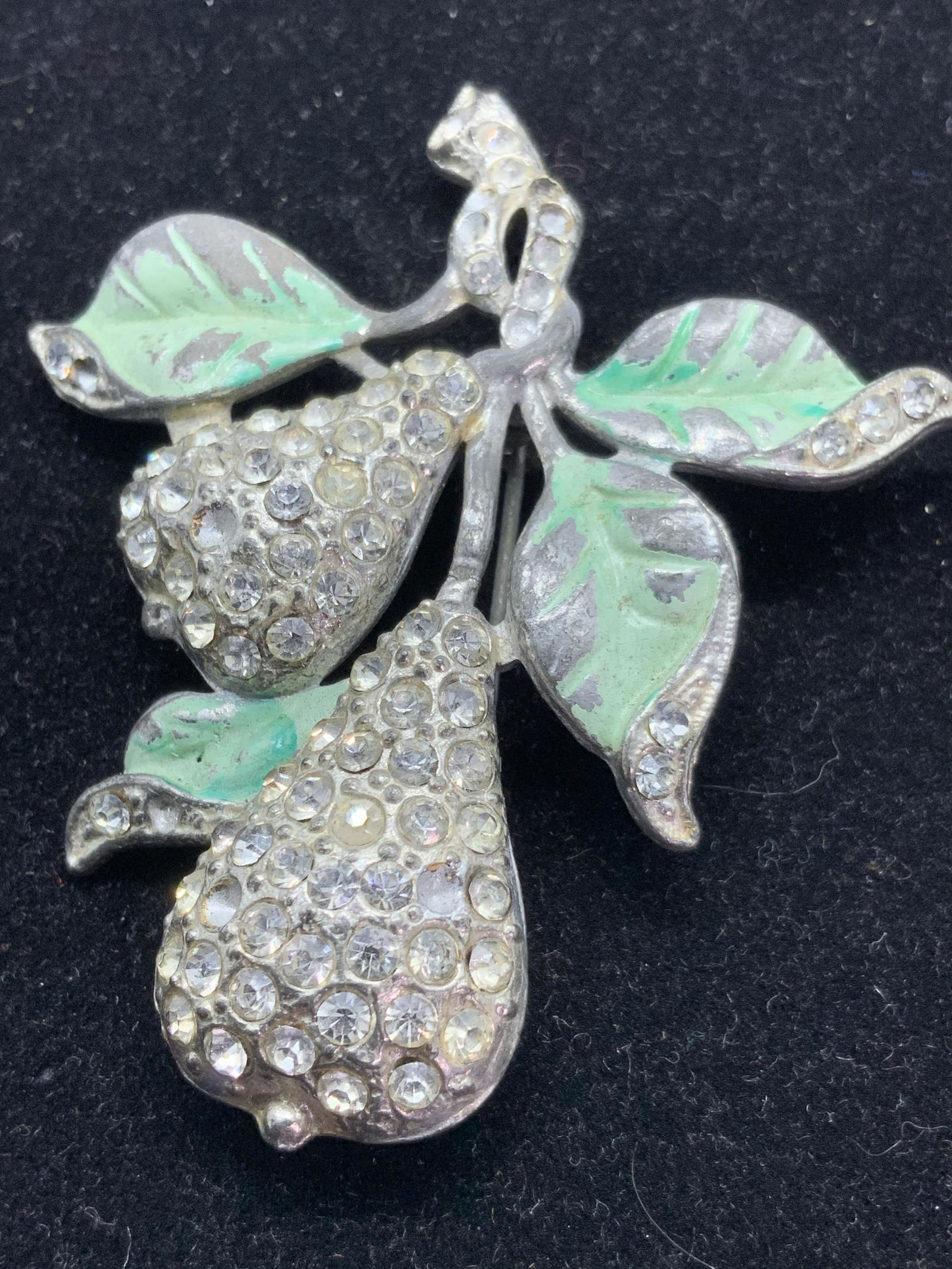 Painted Crystal Pear Brooch, Jewelry: Two pears dangling from a branch with painted green leaves. Pears are decorated with small bezel set clear crystals. Silver toned metal. Underside features polished metal and pin closure. 11 crystals