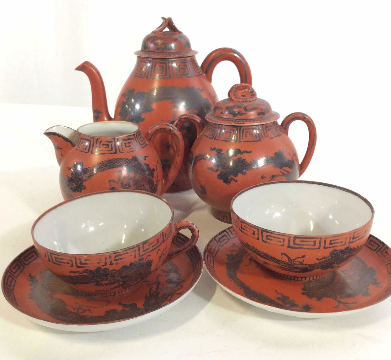 MM Chinaware Asian Tea Set, 7 pcs: porcelain tea set, Hand painted all rust color with classical Asian Greek Key Pattern And Dragon. Creamer, sugar bowl with lid, tea pot with lid, two tea cups and 2 Saucers. Teapot measures 7 in ht, 7