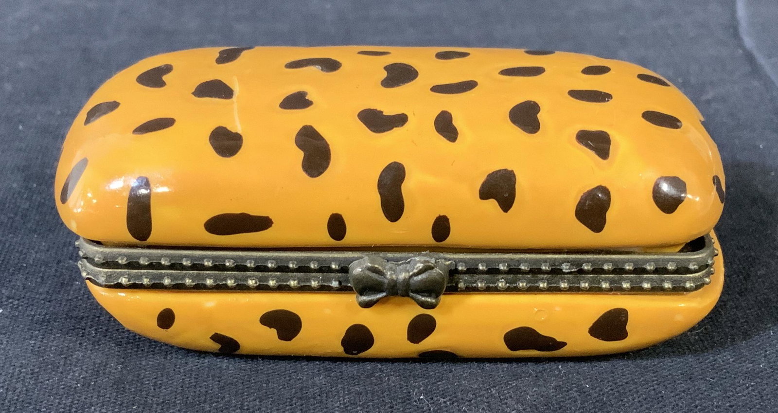 Cheetah Print Pill Box: Cheetah Print Pill Box, no apparent inscriptions or stamps, bow shaped clasp, measures 1 1/8 inches tall x 3 inches long, some surface wear but overall in good condition, Cheetah print, pill box, keep