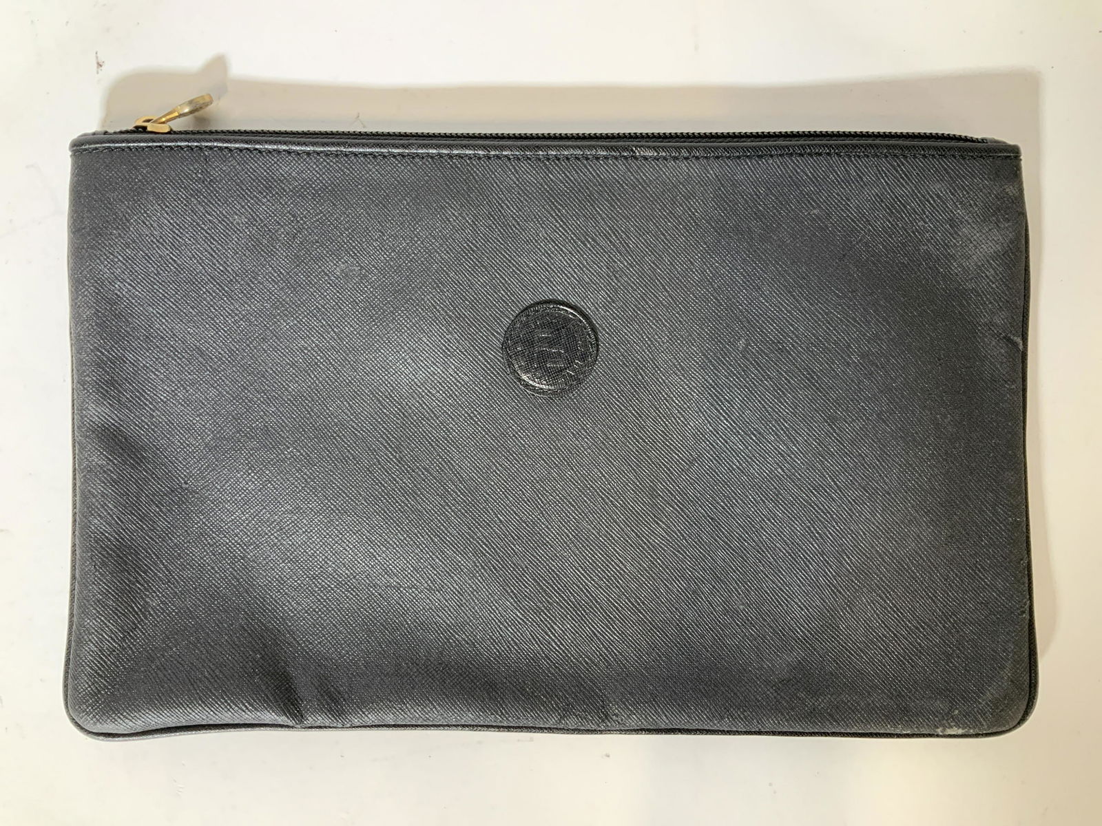 FENDI Black Leather Clutch: FENDI Black Leather Clutch, inscription to bag reads ‘Fendi Roma Italy 1925’, inscription to interior reads ‘Fendi SAS Roma Made in Italy’, measures 7 3/8 x 12 1/8 inches, some wear to exterio