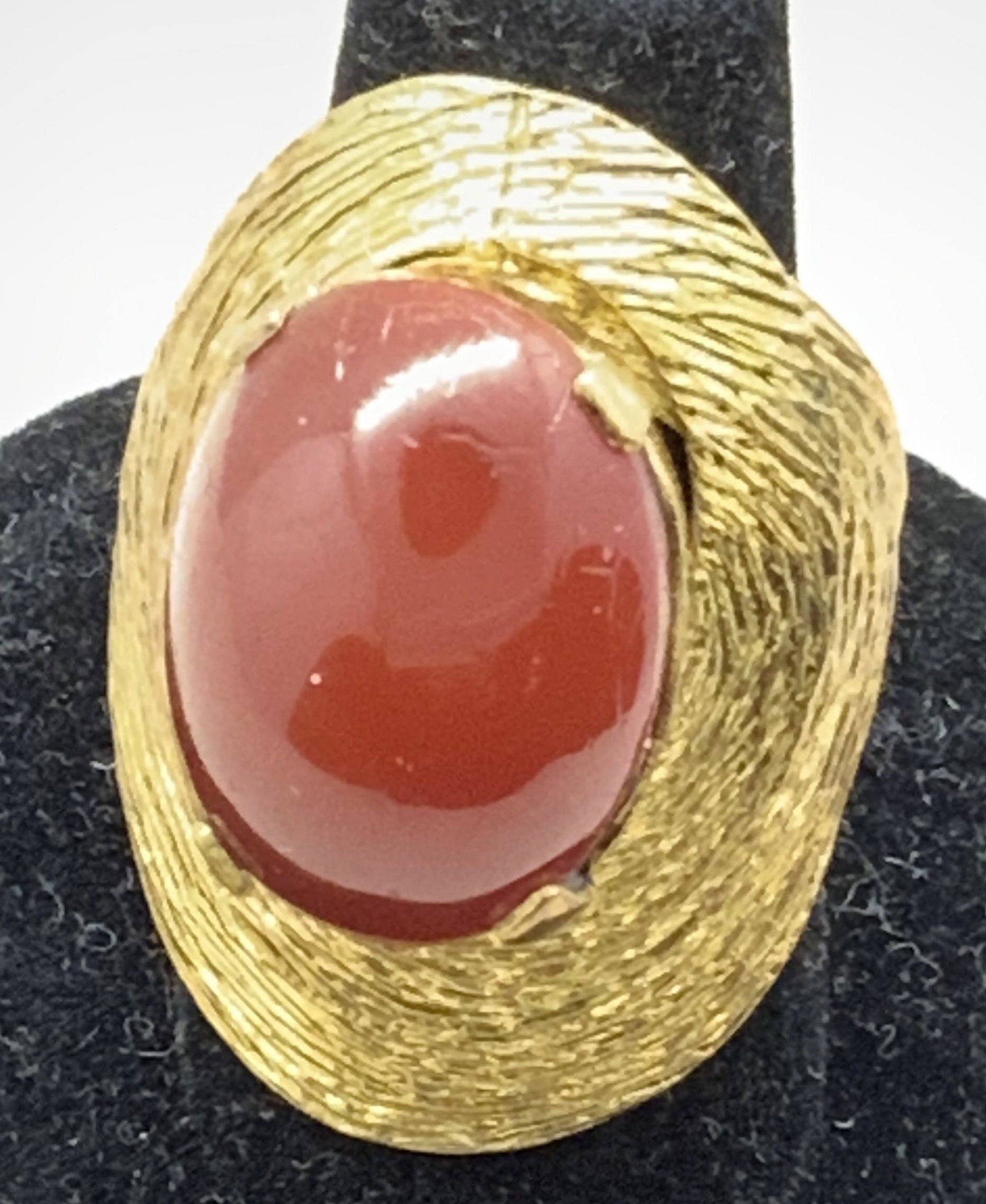 Carnelian Gripoix Cabchon Gold Tn Ring, Jewelry: Central carnelian cabochon, GRIPOIX glass, 15 x 20 mm, in 4 prong setting, surrounded by a wrapped striated etched shell-like shield in shiny gold tone metal. Over all ring dimensions 1 1/4 x 1 1/8 in