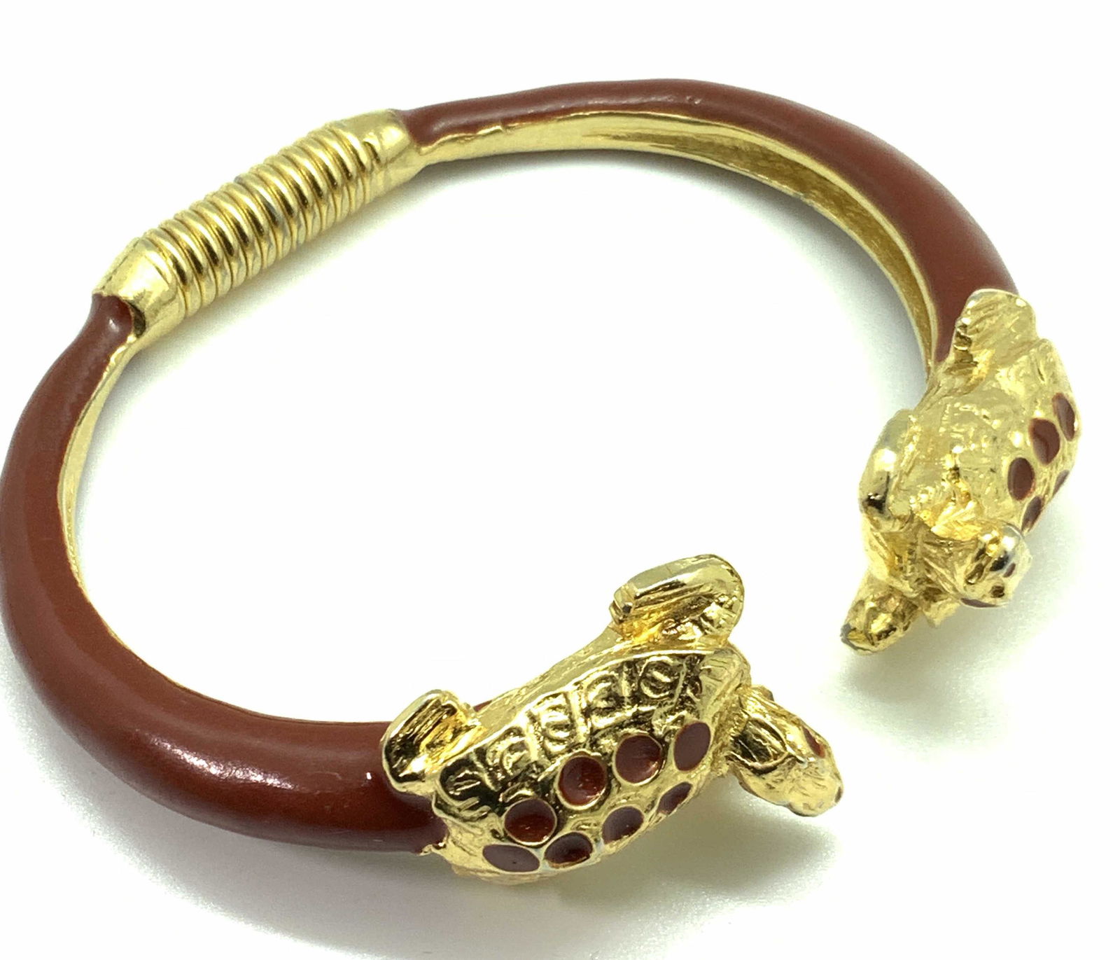 Turtle Figural Gold & Red Tone Bracelet, Jewelry: A gold tone and red enamel bracelet with two turtles on either end. The bracelet is adjustable due to a bendable gold tone wire in the center. Both turtles have etched metal designs and are accents wi