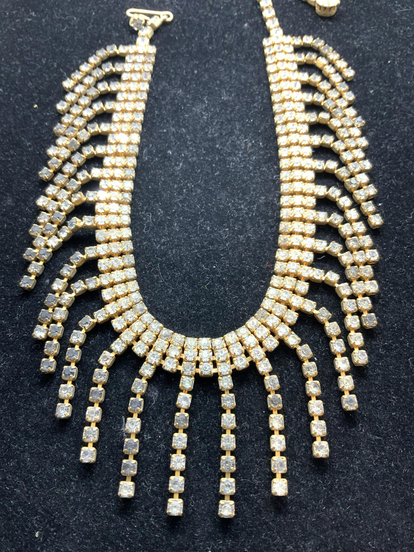 Vintage Art Deco Pendant Rhinestone Necklace: 15 in. Necklace all clear rhinestones showed off in a gold toned metal. C. 1950s- 1960s cocktail jewelry. Single tassel pendants draped from end to end. Hook and large solitaire rhinestone back drop. 