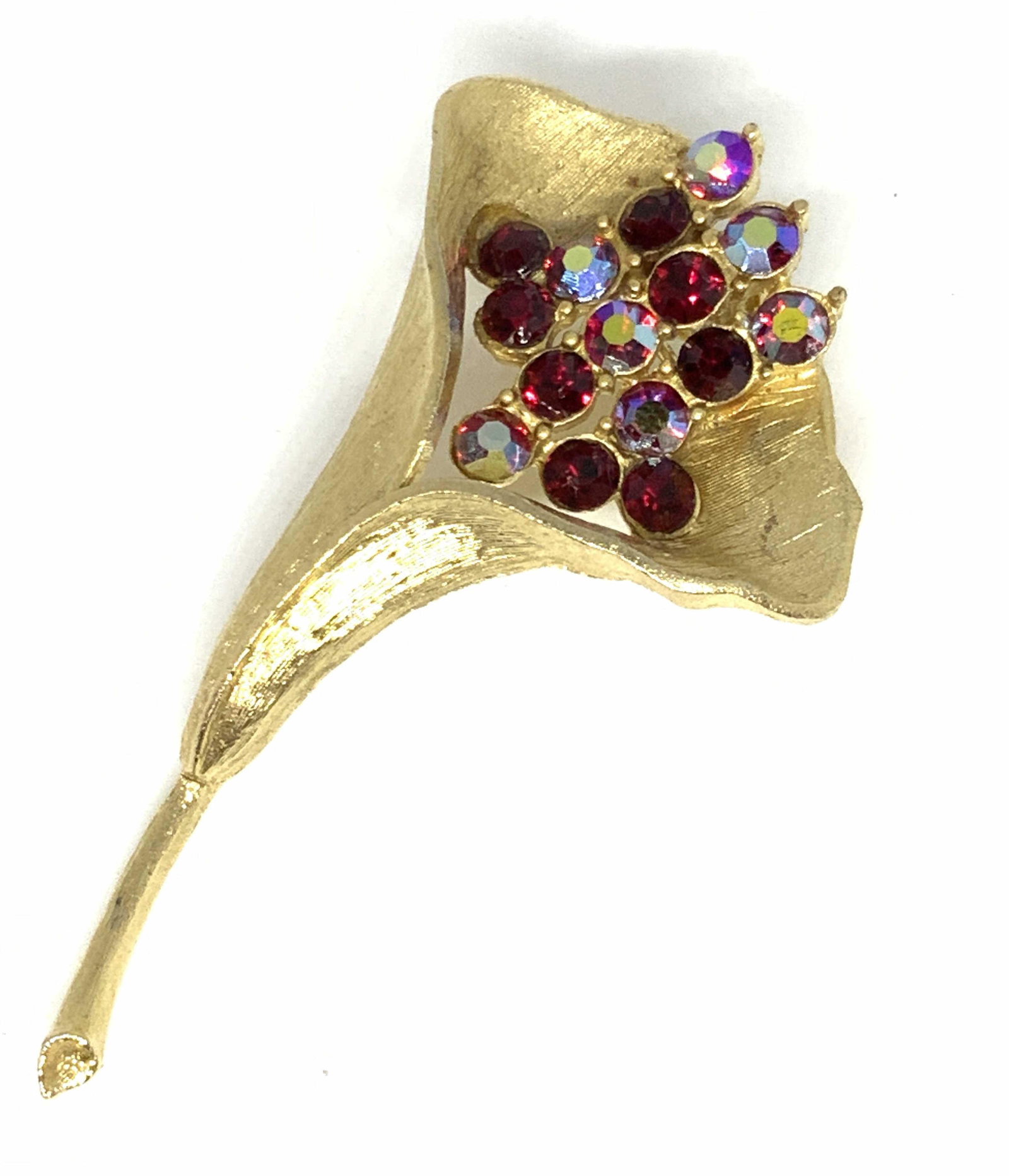 Lot3 Vintage Sculptural Red Crystal Brooches: Three vintage brushed gold tone brooches decorated with red faceted crystals. Each brooch possesses deep ruby red colored crystals. The lily form brooch has iridescent qualities to its red crystals. T