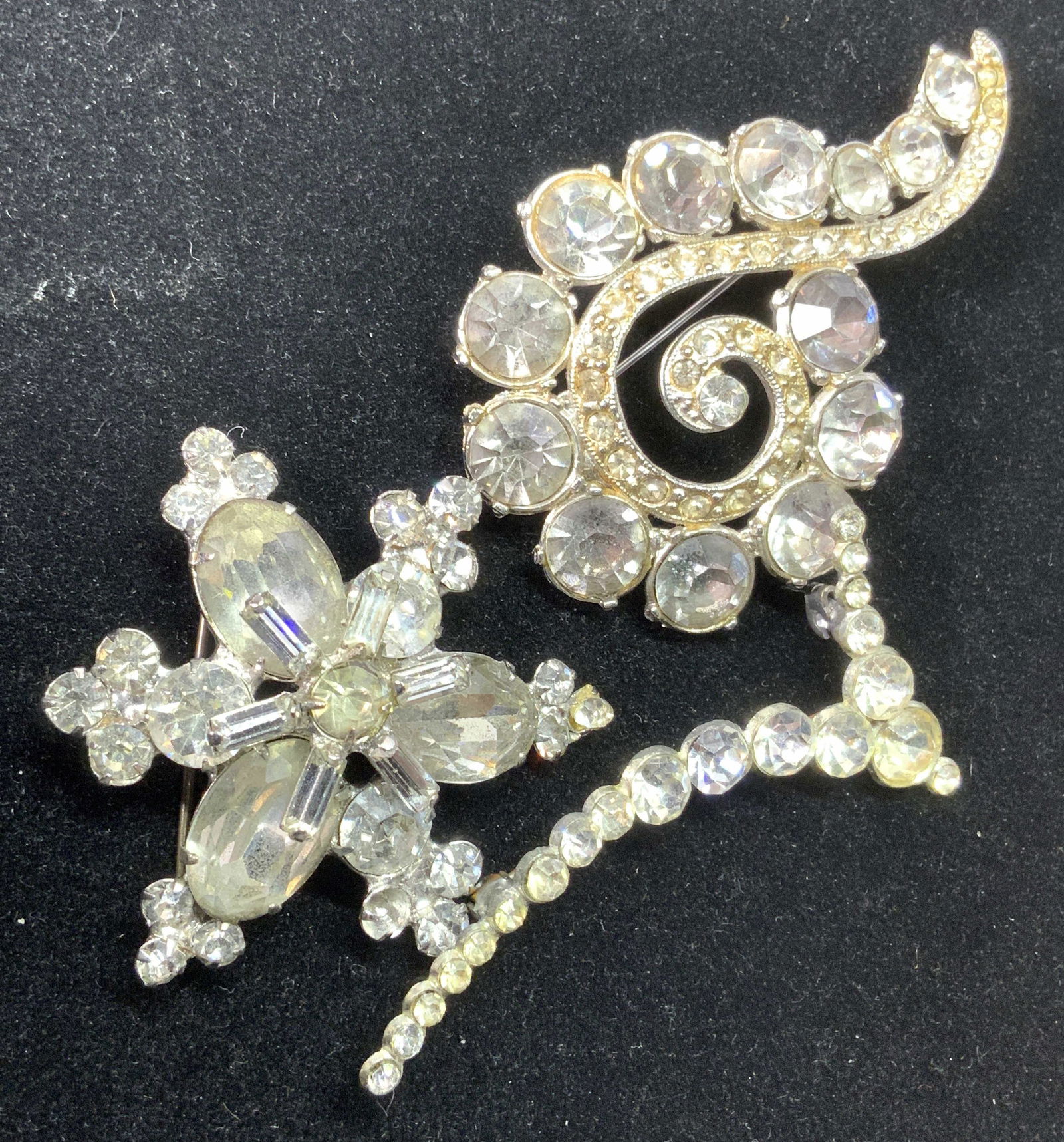 Lot3 Vntg Abstract Crystal Brooches, Coro, more: Lot of three vintage silver tone metal brooches decorated with colorless, faceted crystals. All brooches feature unique abstract shapes that resemble spirals, florals, and linear forms. The crystals a