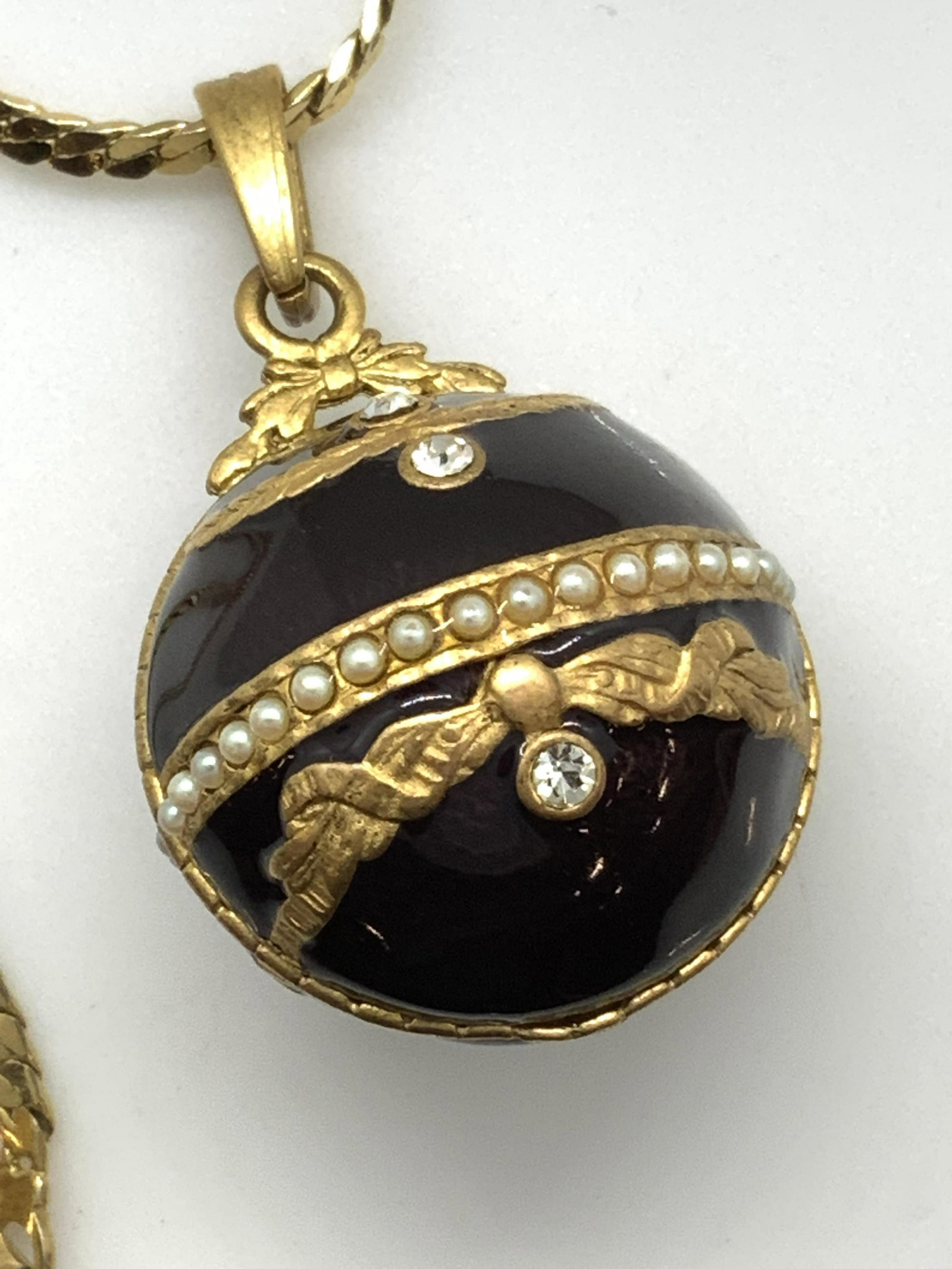 MONET GUILLOCHE ADORNED Sphere Pendant Neck.: Lovely long bone style chain (28 in.) in gold tone, signed on clasp MONET, Pendant FRENCH GUILLOCHE enamel in deep aubergine with embellished French Gold tone laurels in relief adorned with solitaire 