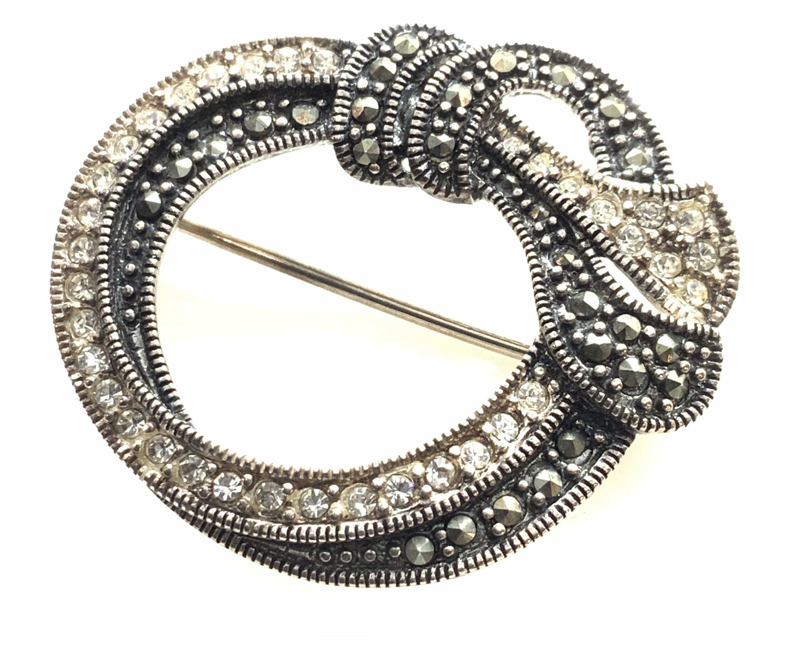 Vintage Sterlling Silver Brooch pin W Marcasite: Vintage sterling silver and crystal and marcasite open circle brooch, made of sterling silver, stamp to reverse reads ‘925A China’, measures at .25 oz, piece depicts a tied circle, measures 1.5 in