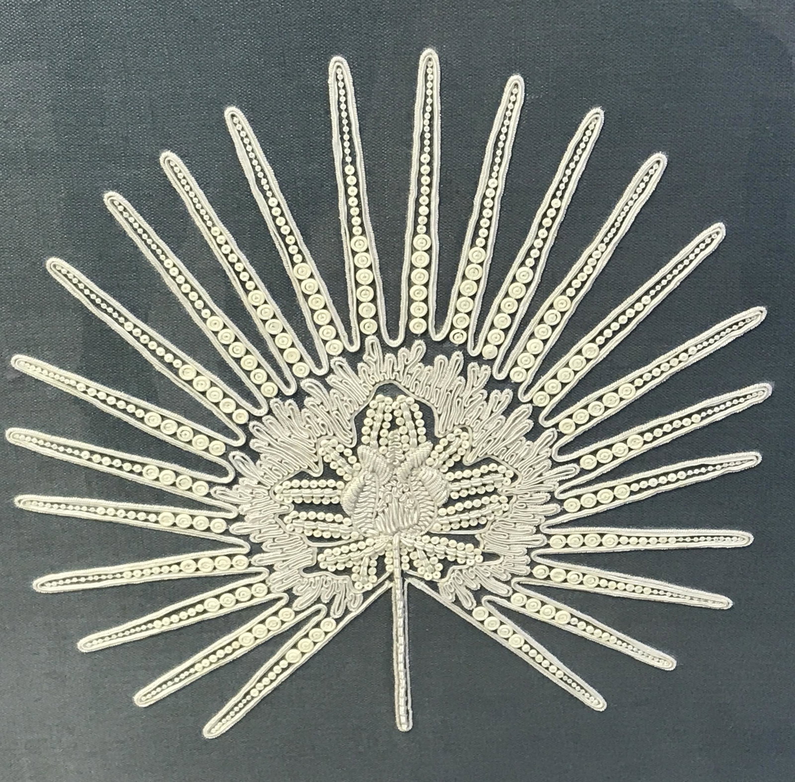 Mounted Embroidered Linen in Shadowbox: Mounted Embroidered Linen in shadowbox, label to reverse reads ‘Trowbridge’, subject a board of blue linen with white embroidery and beads in the shape of a leaf mounted on a board, white matting,