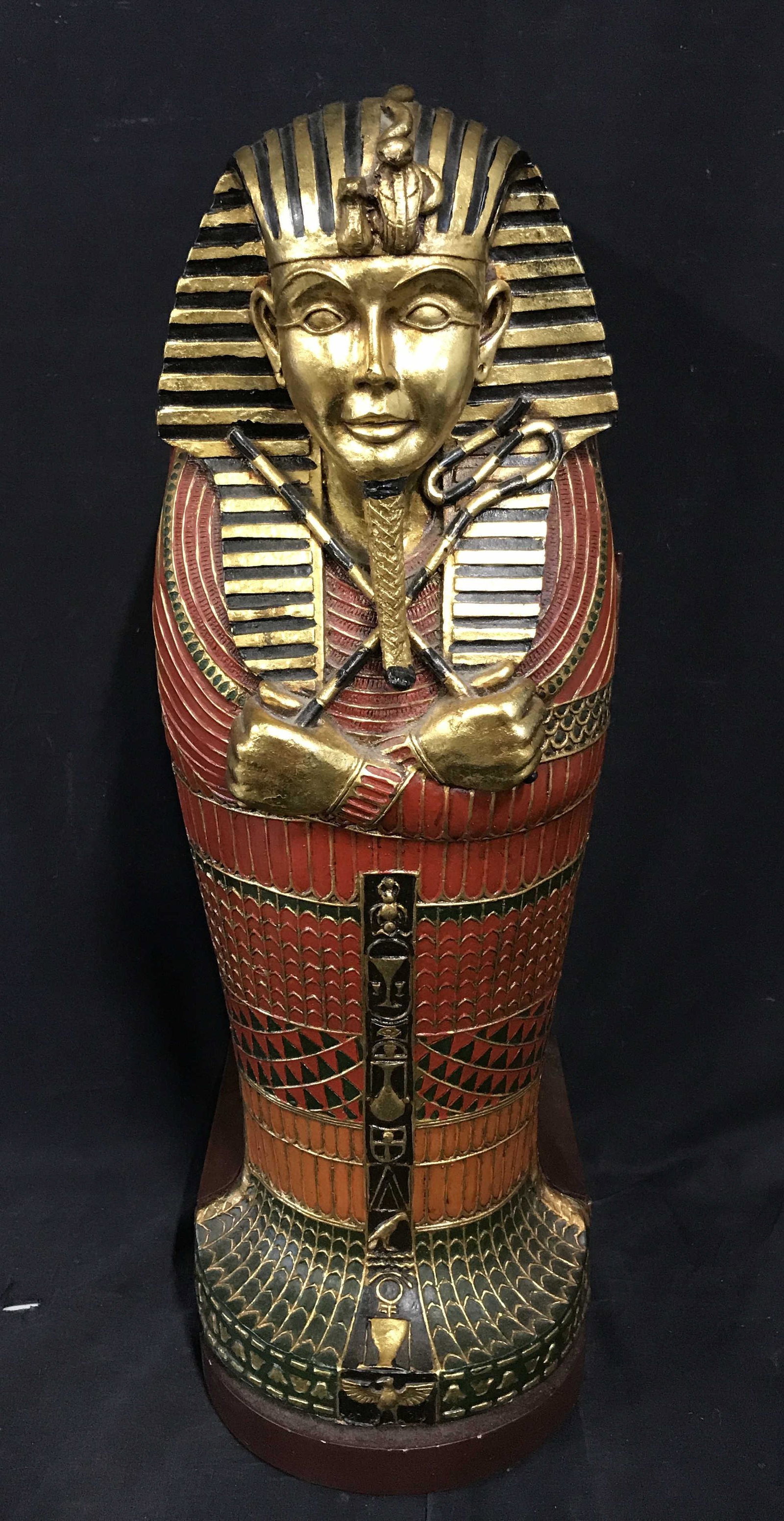 Wooden Sarcophagus Shelving Unit: Wooden sarcophagus shelving unit, exterior of shelf appears as an Egyptian sarcophagus standing up, front of piece is painted in bold colors of orange red green and gold, the rest of the piece is pain