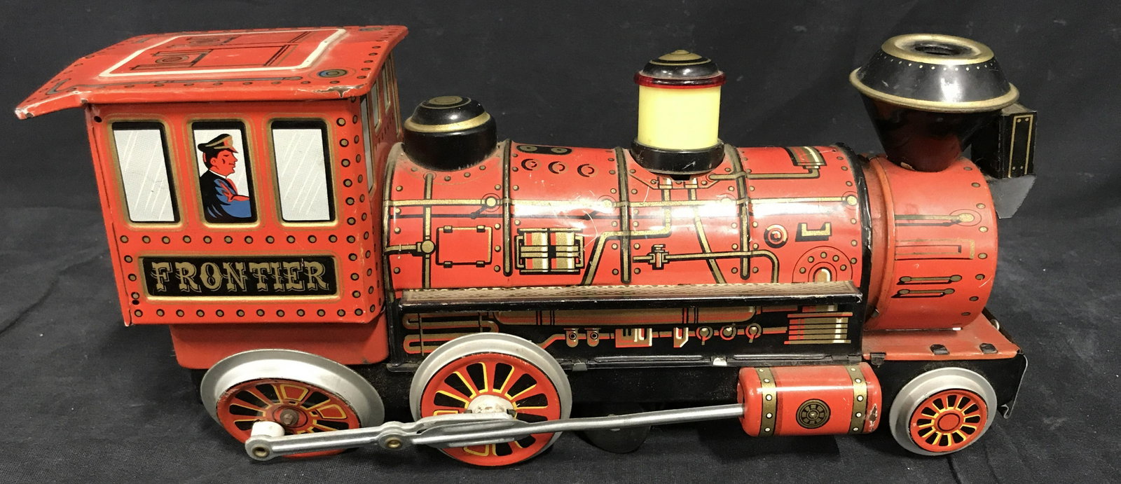 Vintage FRONTIER Western Tin Toy Train: Vintage FRONTIER Western Tin Litho Trade Mark Toy Train, back of train has on switch as well has compartment for batteries, toy train is the engine car displaying the conductor in the cabin, wheels ne