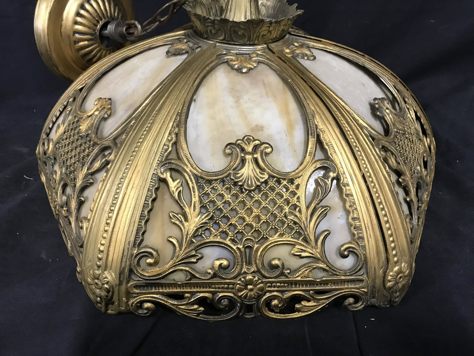 Baroque Style Hanging Light Fixture: Baroque style hanging light fixture, body of piece is made of a gold metal with ornate detailing, body of piece has 6 main windows with colored glass to each section, measures approximately 18 inches 