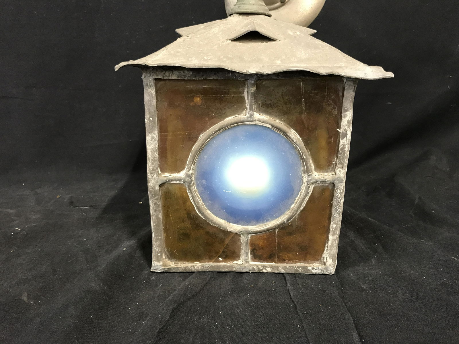 Metal and Slag Glass Hanging Outdoor Lantern: Metal and stained glass hanging outdoor lantern, frame/body of lamp is made of a heavy rough grey metal with stained glass windows in yellow and blue, needs to be electrified, take a single bulb, meas