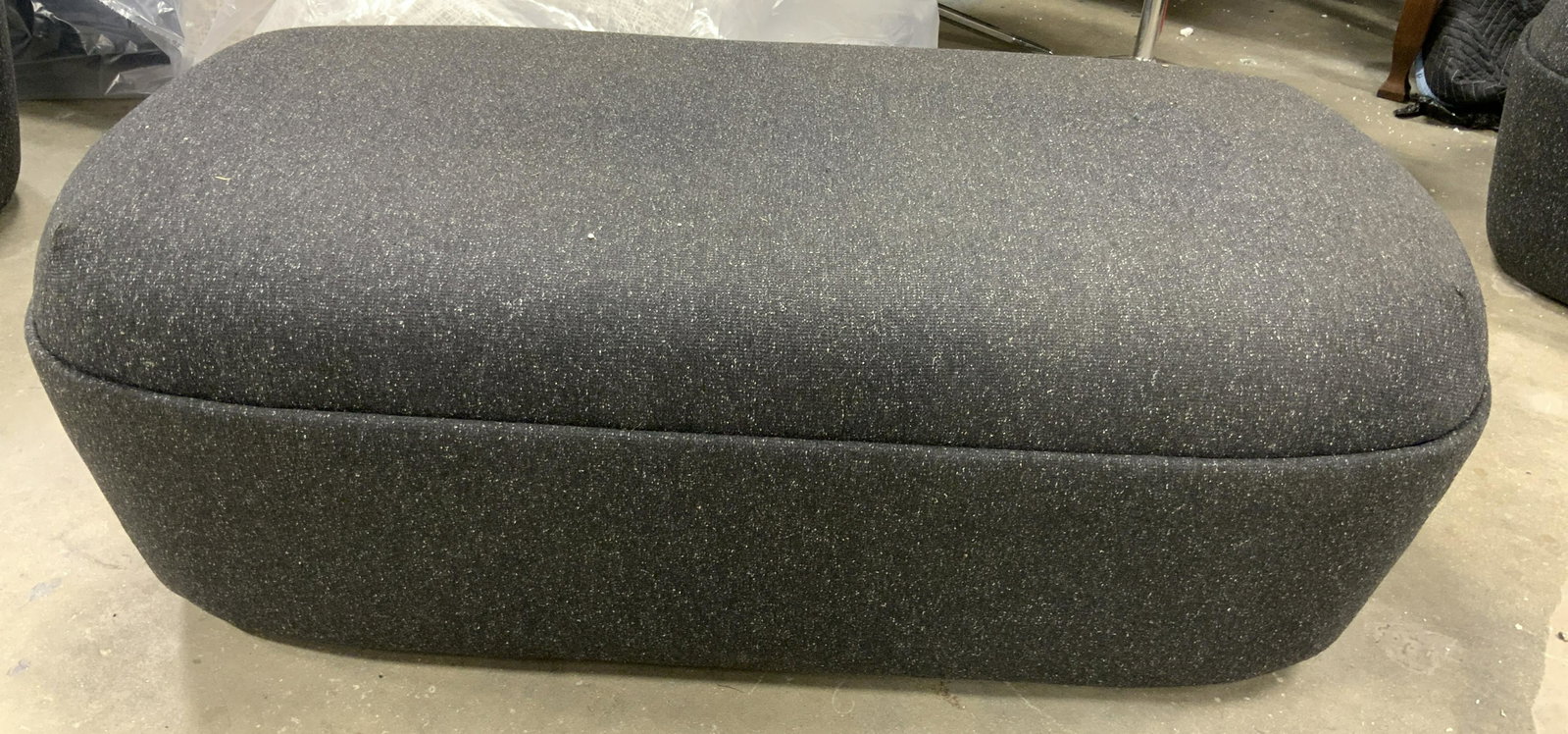 STUDIO TK CESTO Bench Ottoman on Casters: Upholstered CESTO BENCH by STUDIO TK. UPHOLSTERY IS ash toned. Measures approx 17.75 inches H, 51.5 inches W, and 25.25 inches deep. Base is plastic and on wheels. Wear is consistent with age and use.
