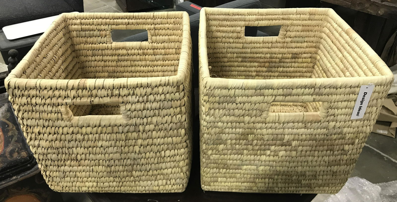 Pair DESIGN IDEAS BRYN Baskets: Tag in pieces read DESIGN IDEAS BRYN BASKET. Each are sand toned with woven structures. Both have handles on each side. Each measures approximately 13 inches tall and wide 14 inches deep. Baskets, BRY