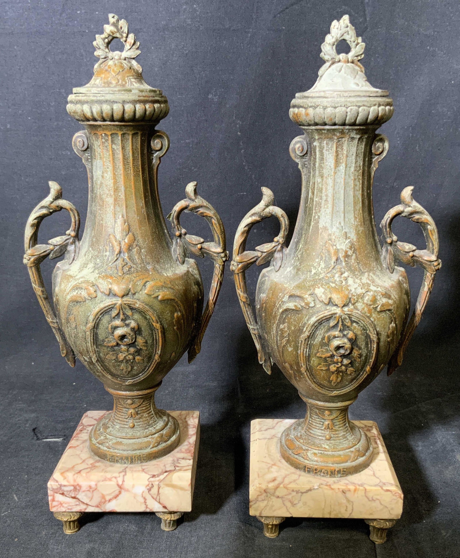 Pair Antique French Signed Lidded Urns: Pair Antique French signed lidded urns, marble footed base, made of a painted metal, inscription to the base of each reads ‘France’, both urns are in an amphora shape, both have floral designs to 