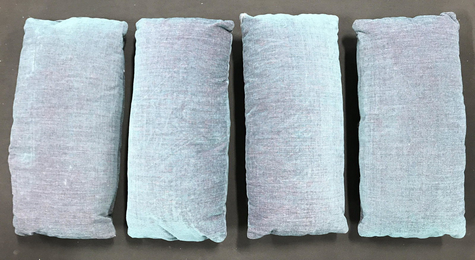 Set 4 Teal Toned Throw Pillows: Set 4 of teal toned throw pillows. Each measures approx 20 inches long, 9.5 inches W. Proceeds will be donated to DIFFA in NYC. Pillows, throw pillows, pair of pillows, home decor, living room decor. 