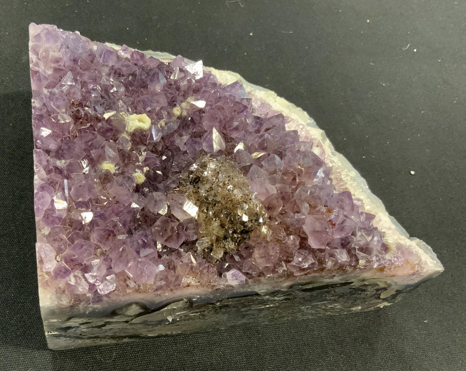 CURATED KRAVET New Large Purple Quartz Geode: New and packaged merchandise donated by Curated Kravet, lot includes a large purple Quartz crystal geode, item has blue and grey striation to the sides, items new in wrapping, perfect for holiday gift