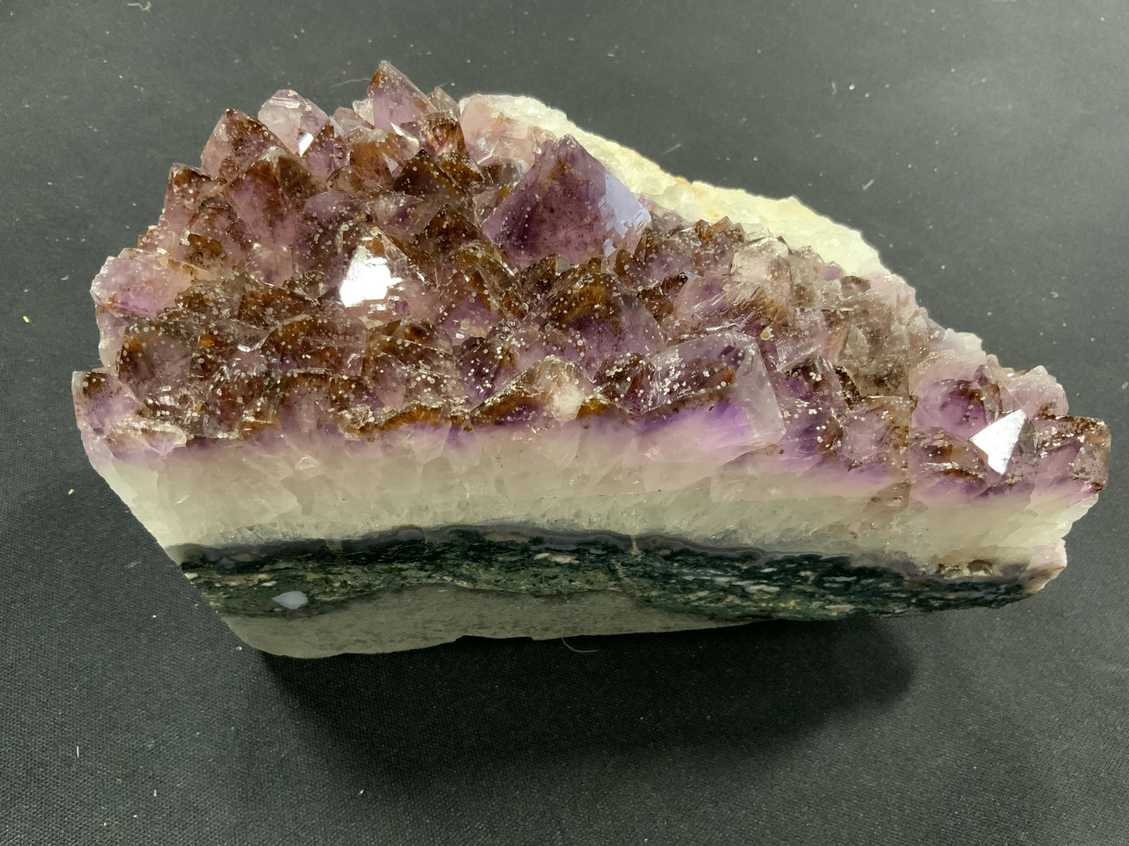 CURATED KRAVET New Large Purple Quartz Geode: New and packaged merchandise donated by Curated Kravet, lot includes a large purple Quartz crystal geode, item has thick layers of white and gray blue to the sides, items new in wrapping, perfect for 