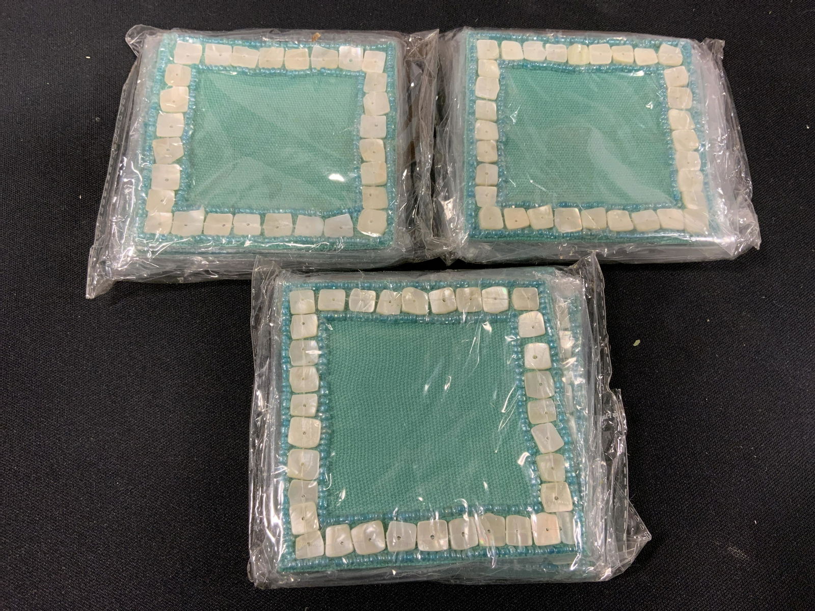 Lot 6 ARCADIA HOME Accessories: New and packaged merchandise donated by ARCADIA HOME, 3 (4pks) of mother of pearl coasters, and 3 felt picture frames, items new in wrapping, perfect for holiday gifts, proceeds from the sale of this