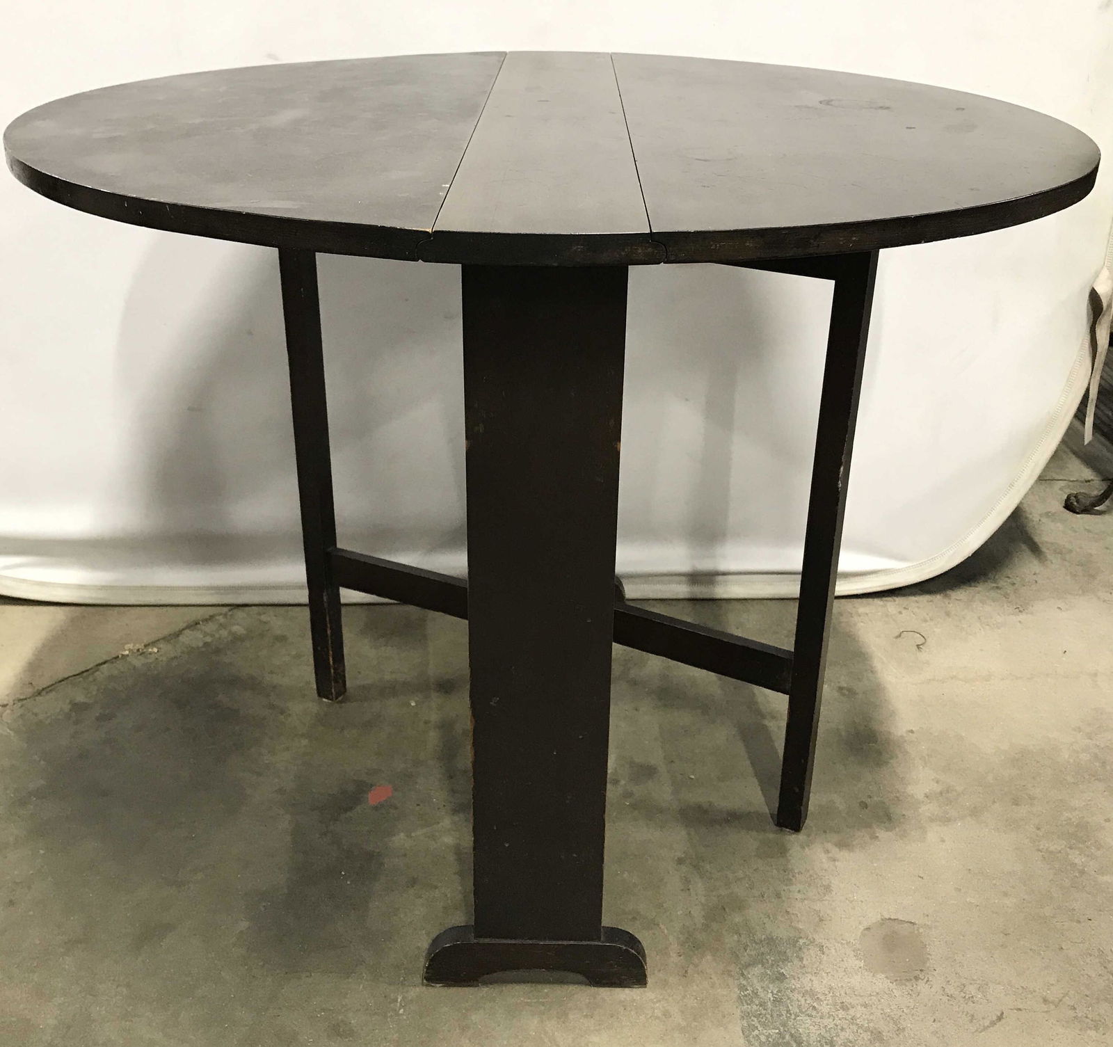 Antique Carved Wooden Drop Leaf Table: Table is wooden. Piece has dark chocolate tone. Piece has 2 rotating leg supports for table leafs. Drop leaf table, antique drop leaf table, wooden drop leaf table. Piece measures approximately 36 inc