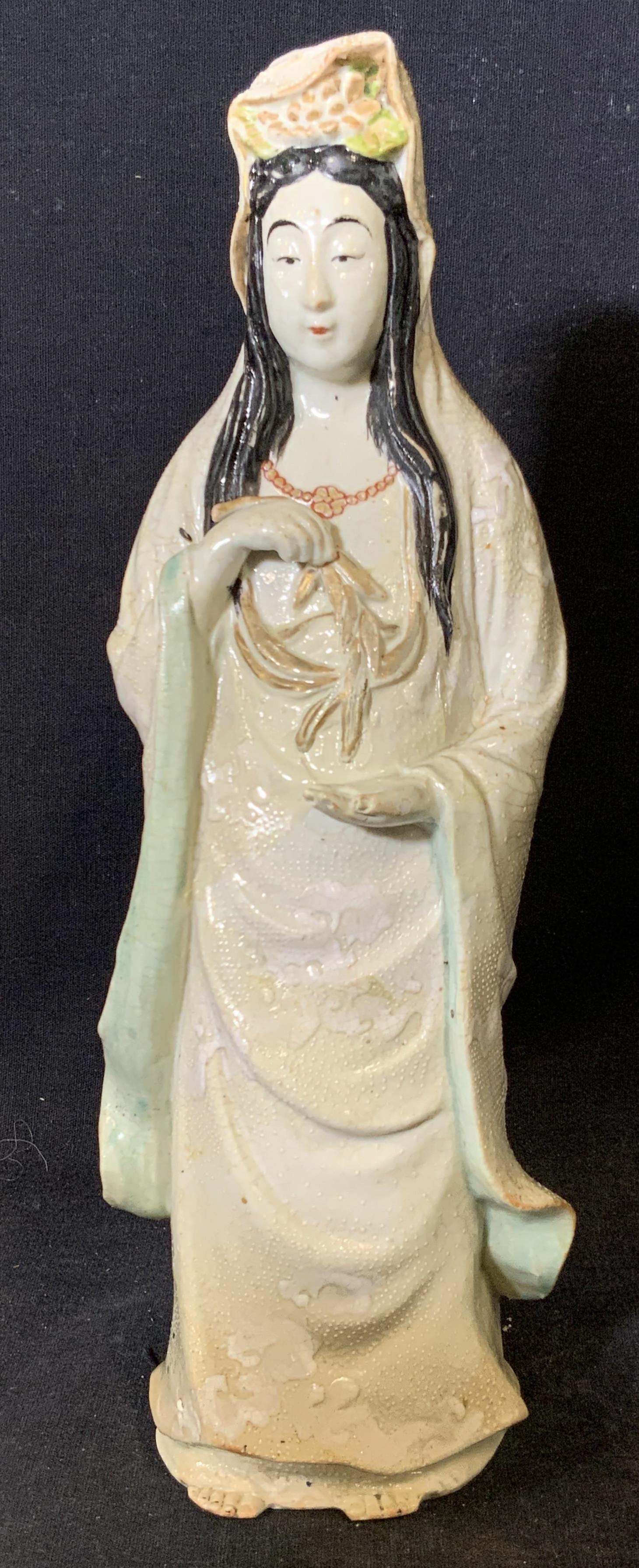 Asian Porcelain Female Figural Statue: Asian porcelain female Figural statue, no apparent inscriptions or signatures, subject a female figure in traditional robes holding leaves, painted entirely with light colored pastels except for her h