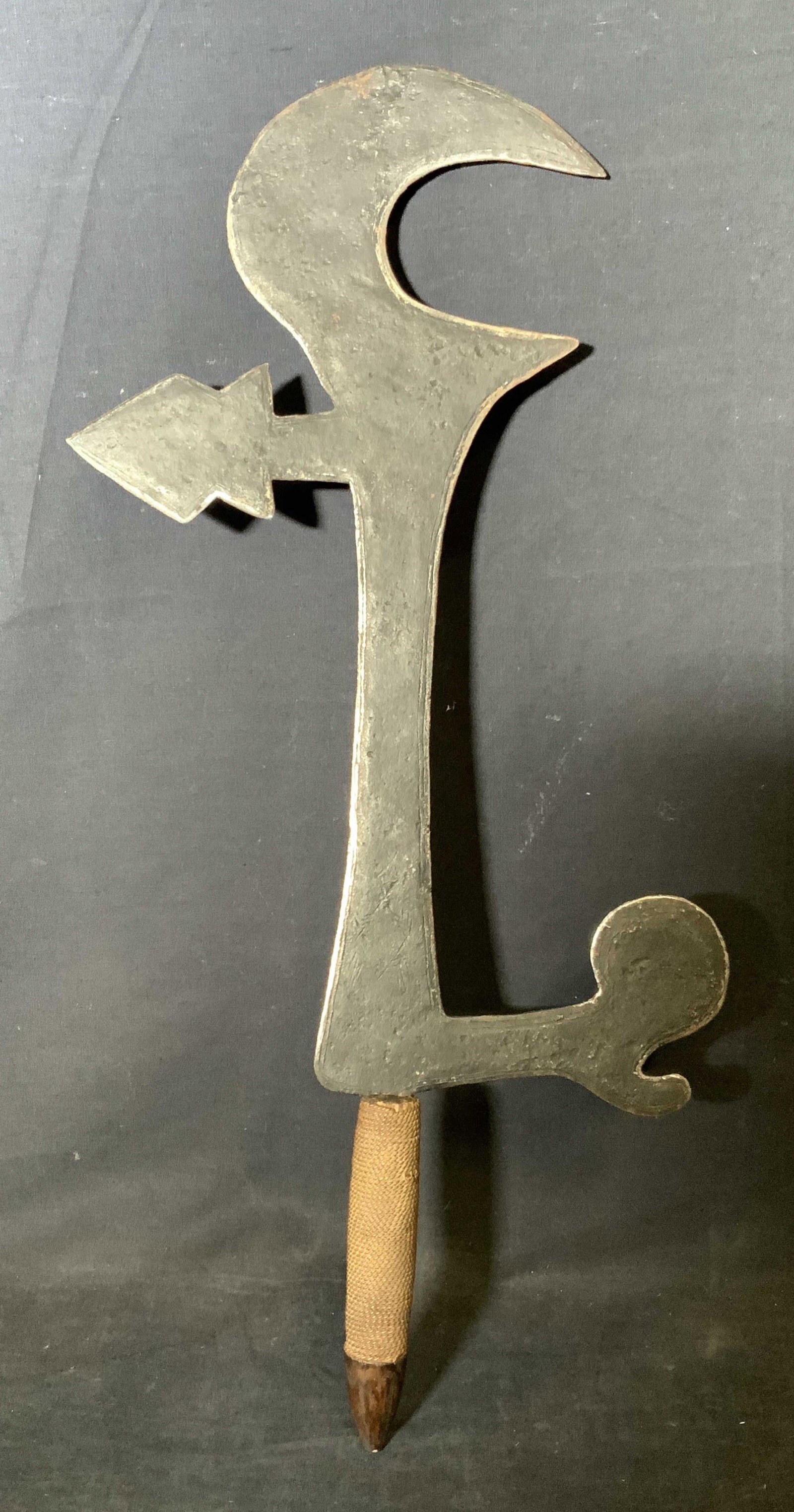Decorative Ceremonial Blade Weapon: Decorative blade, no apparent inscriptions or marking, blade has a small hooked end with two decorative arms branching from its main body, blade appears to be at half tang with a metal rope coiled aro