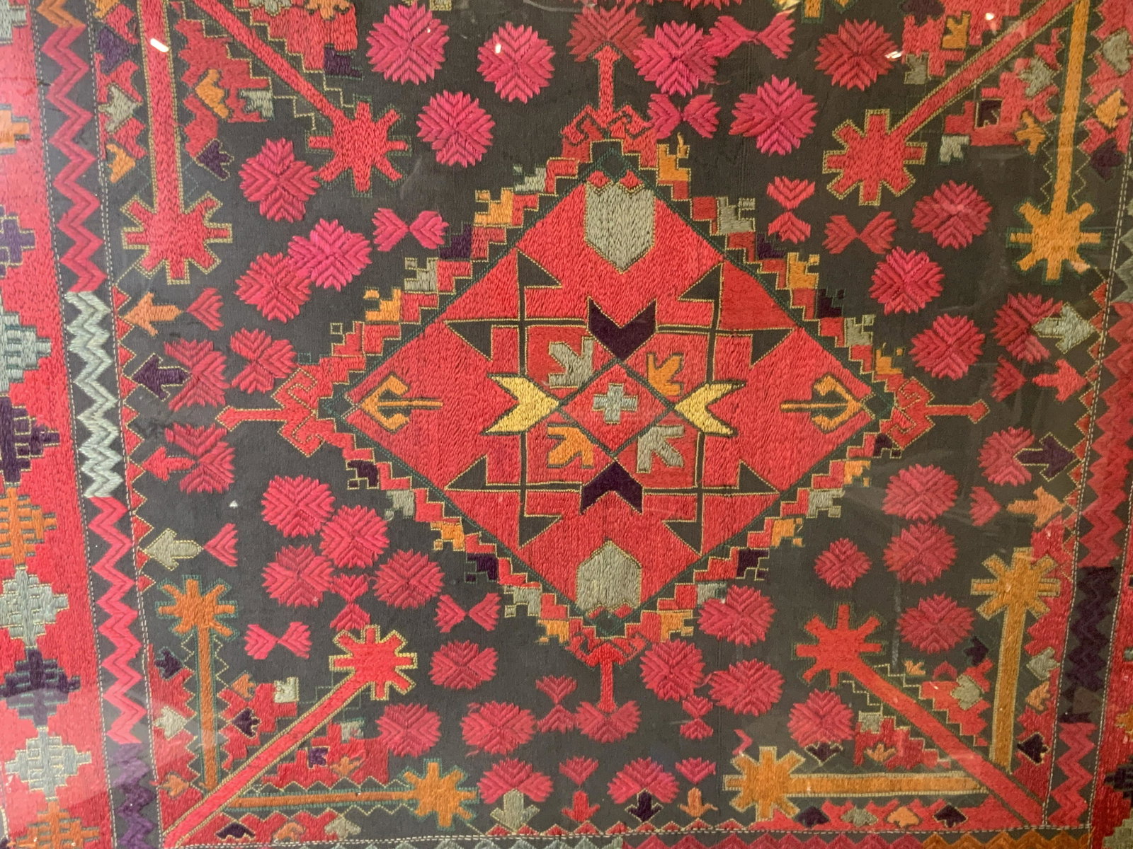 Antique Framed Geometric Patterned Textile: Antique framed geometric patterned textile, no apparent markings or inscriptions, label to reverse reads ‘Rampo Picture Frames’, subject a grey fabric with bright pink light blue orange and purple