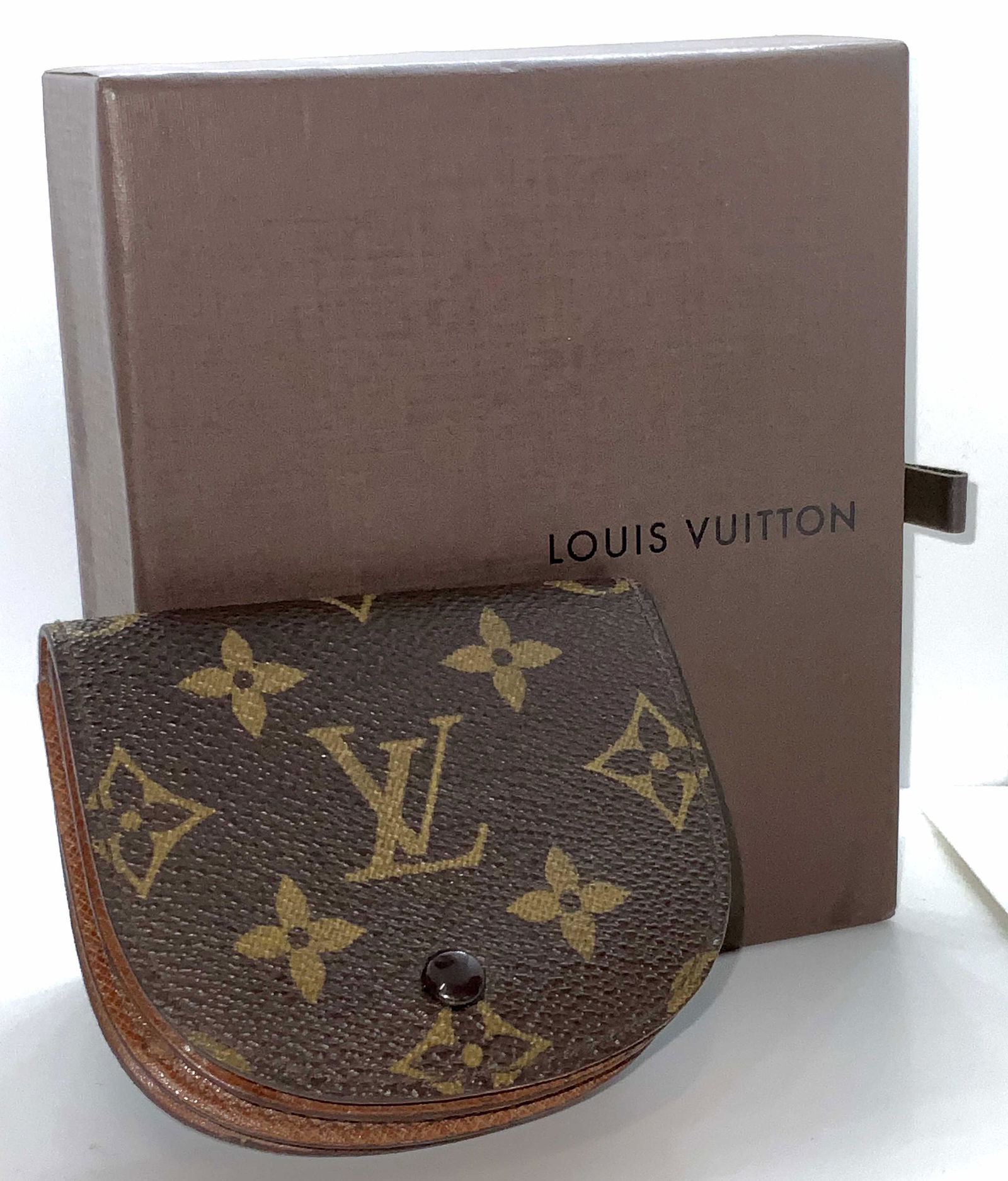LOUIS VUITTON Signed Wallet W/ Original Gift Box: A signed Louis Vuitton wallet. Classic monogram with iconic ‘LV’ trademark. Various brown tones throughout. Has three interior pockets, snap button closure. Interior signed: Louis Vuitton Paris Ma