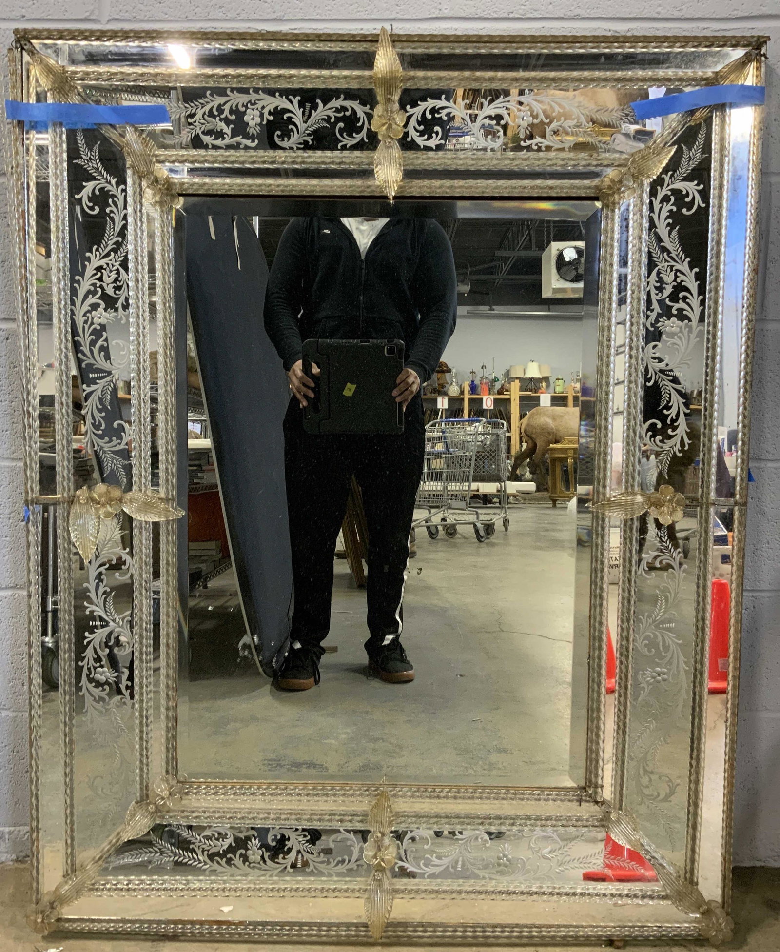 Vintage Multi Panel Venetian Mirror: Mirror is vintage. Piece has multiple panels of glass. Piece has ornate frosted floral vine & leaf detail. Piece measures approx 50 inches tall 39 inches wide. Mirror also has glass floral & leaf orna