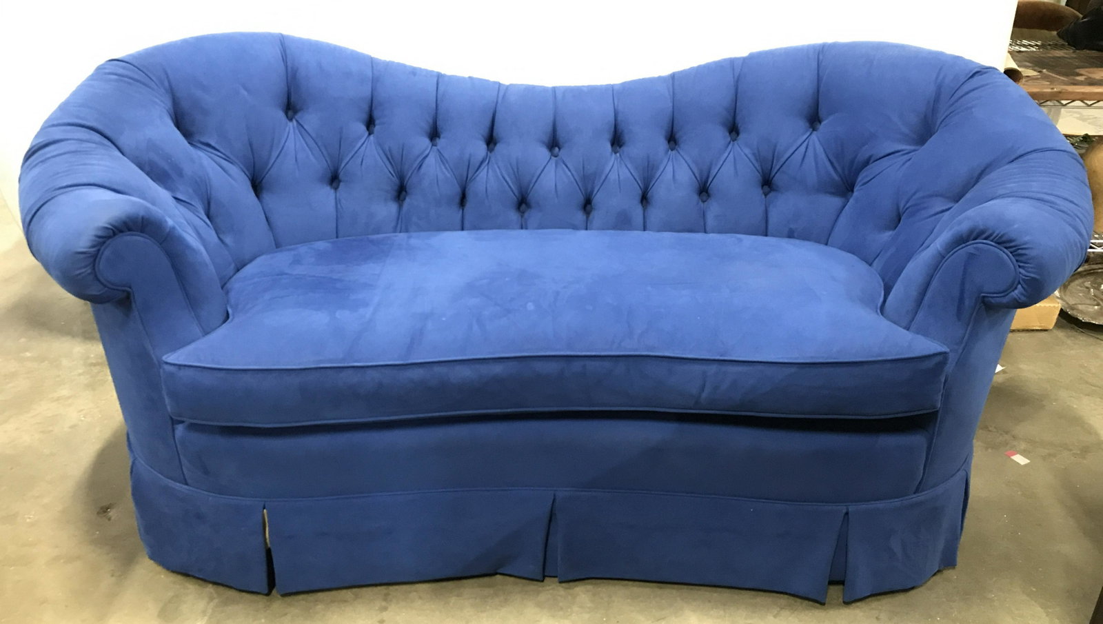 Blue Tufted Skirted Love Seat, Chesterfield Style: Chesterfield style, partial u shaped sofa, newly upholstered but possibly vintage Baker Piece. Loveseat is blue toned. Piece has tufted backrest and curled over armrests. Sofa is skirted. Backrest dip