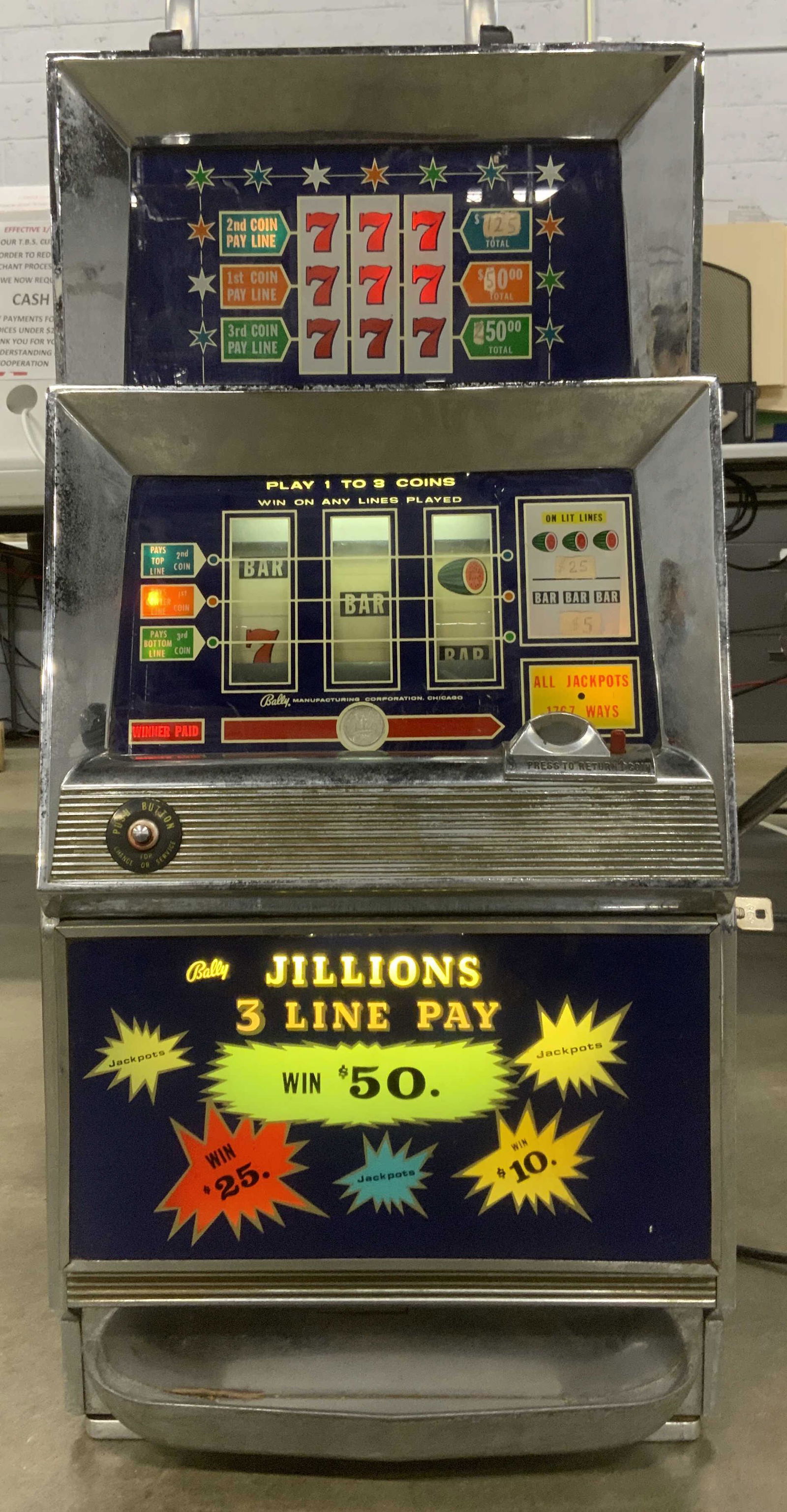 BALLY JILLIONS Vintage Coin Operated Slot Machine: Vintage BALLY coin operated slot machine. PIECE HAS SIGNIFICANT WEIGHT. Lights up when plugged in, pull lever stuck, needs attention. Key to open face included with machine. Measures approx 34 inches
