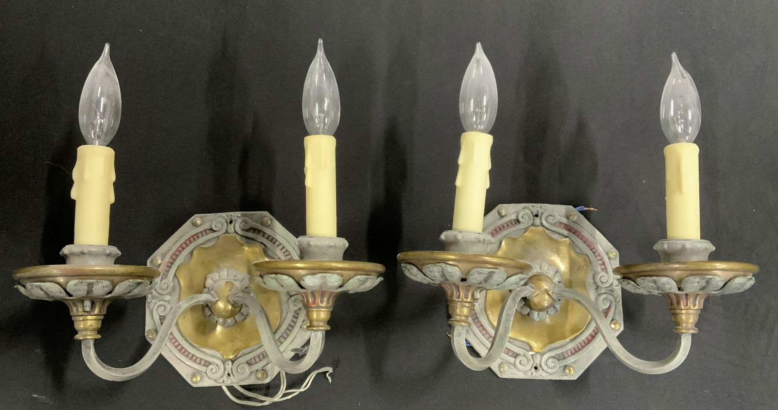 Pair Vintage Hand Painted Brass Sconces: Pair of brass wall sconces. Double socketed, each socket resembles a melting candle, sconces hand painted in blue-grey tones, some detailing highlighted with red paint. Each measures approx 12 inches