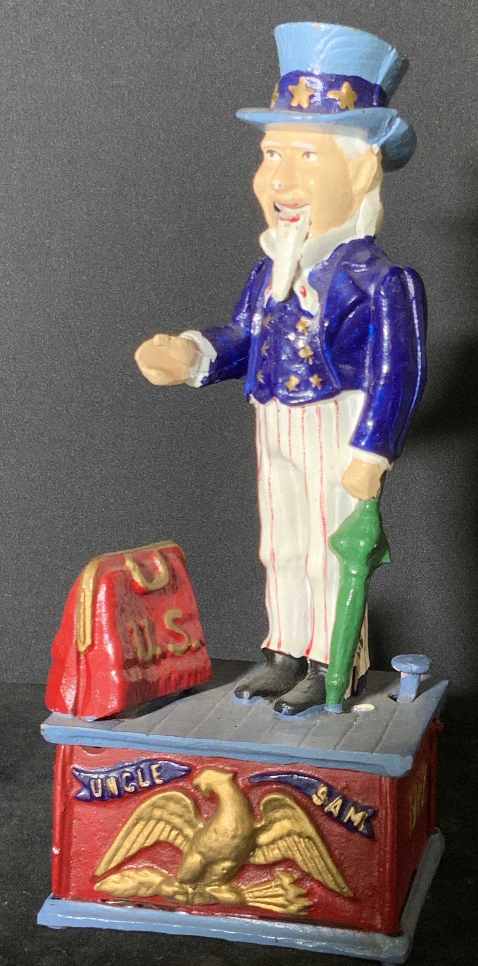Vintage UNCLE SAM Mechanical Iron Coin Bank: A vintage possibly antique hand painted Uncle Sam figural coin bank crafted from cast iron. The design features Uncle Sam, a purse marked U.S., and an Eagle spread winged, in relief gold toned bird. T