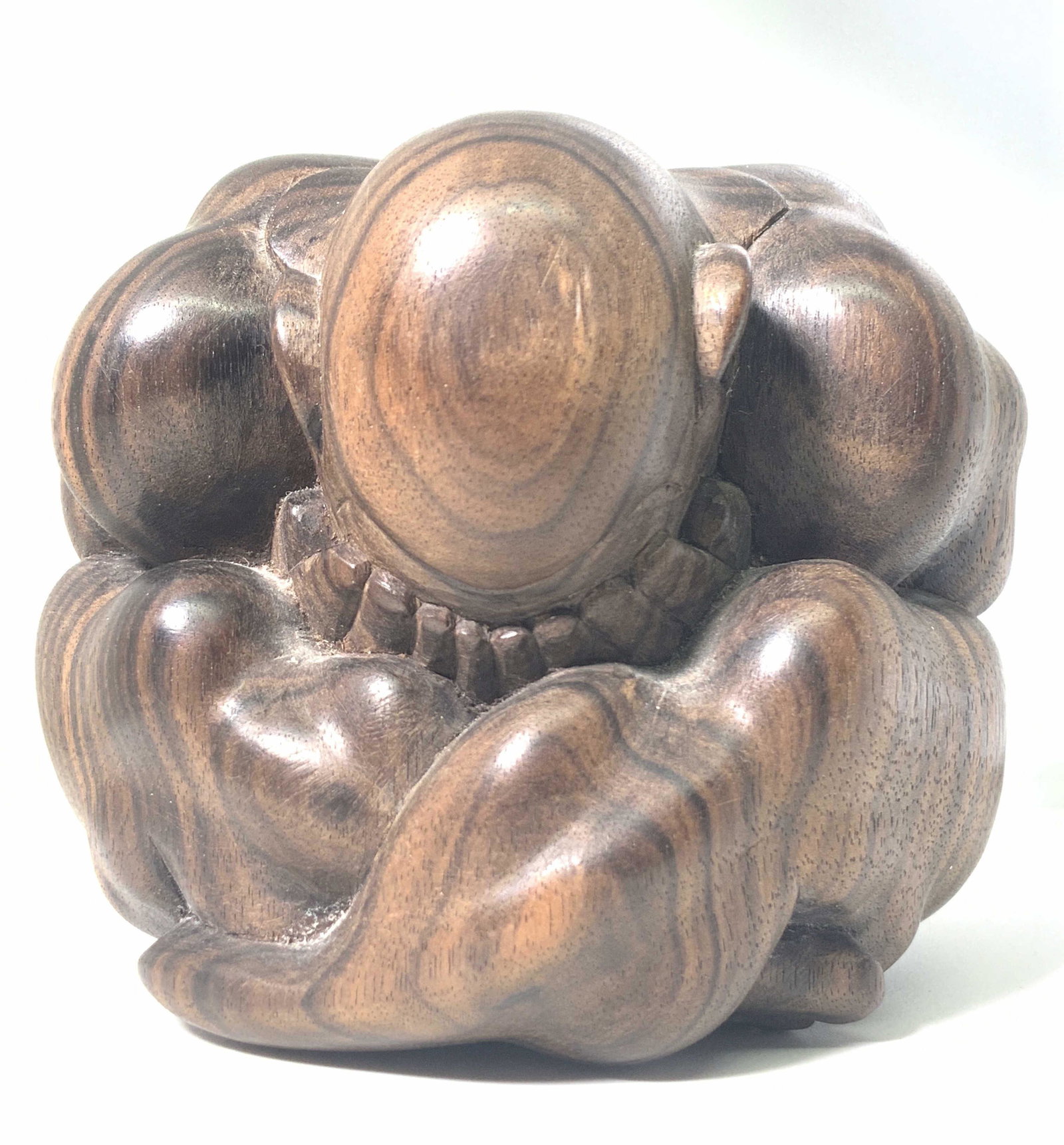 Carved Rosewood WEEPING BUDDHA Figural: A carved figural depicting a weeping Buddha. The figural is carved from a deep brown, polished rosewood. The Buddha is depicted curled in upon himself, with his face in his hands and bent. Piece is we
