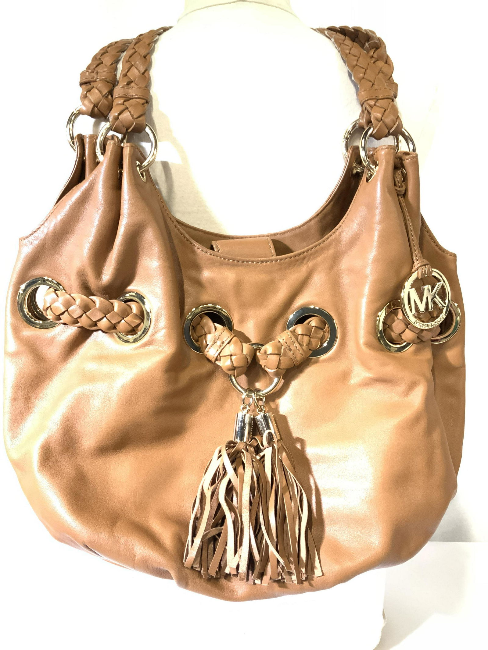 MICHAEL KORS Tassel Braid Grommet Leather Handbag: Vintage Michael Kors Leather bag, smooth leather that is soft with MK logo fabric interior lining. Gold tone MK ACCESSORY ORNAMENT, signed MICHAEL KORS, Tight & neat stitching. Magnetic Snap closure s