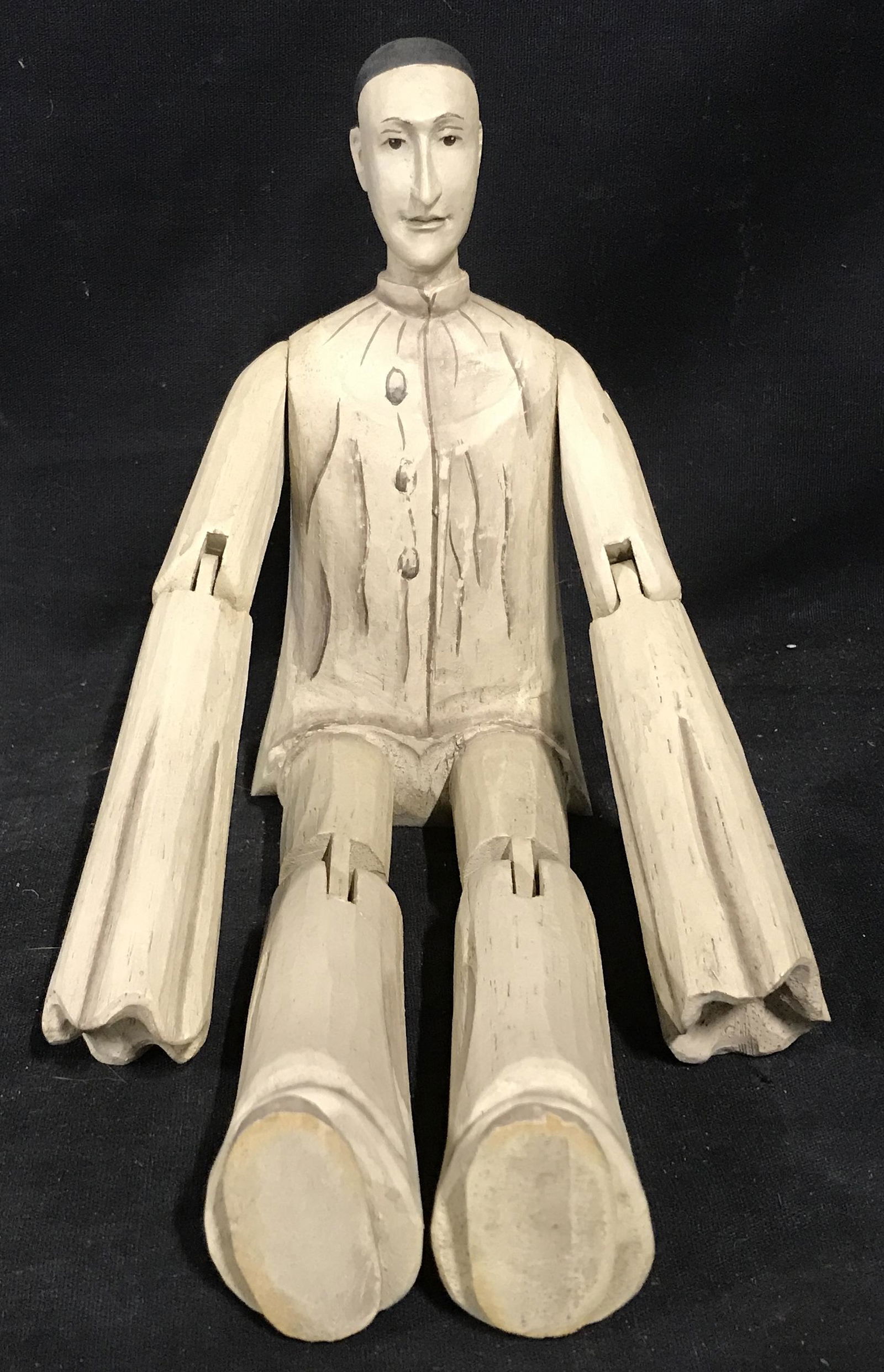 Wooden Puppet Doll: Wooden puppet doll, no apparent marks or stamps, painted almost entirely white with some grey accents for depth as well as a black and white painted face, made in a seated position, measures 6.5 inche