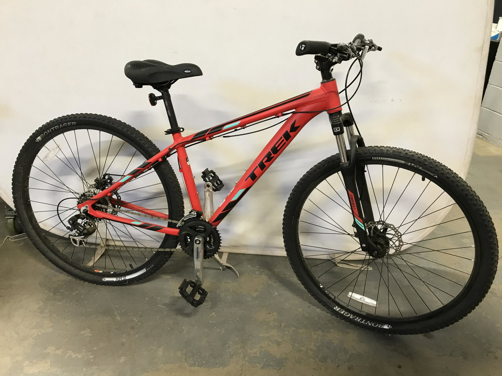 TREK MARLIN 5 Bicycle: TREK MARLIN 5 bicycle. Red black and turquoise tones. Measures approx 68 inches W, 41 inches H. Tires need refilling/replacing. Wear is consistent with age and use. Bike, trail bike, off road bike, mo