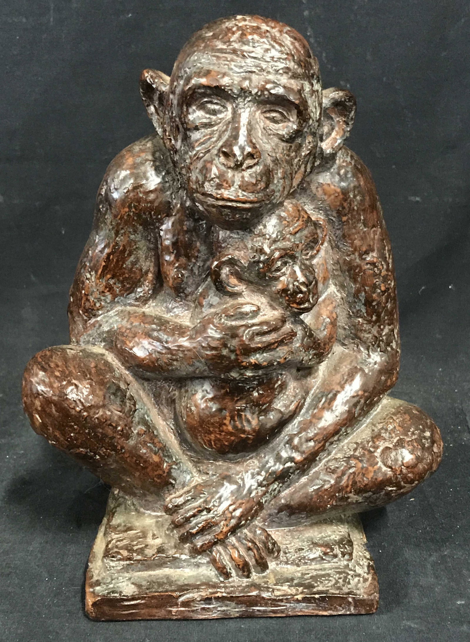 Solid Wood Monkey Statue, Artwork: Solid wood monkey statue, no apparent marks or stamps, subject a monkey seated with its baby in its lap, painted in a reddish brown, some scuffs and chips to surface, measures 9.75 inches at tallest, 
