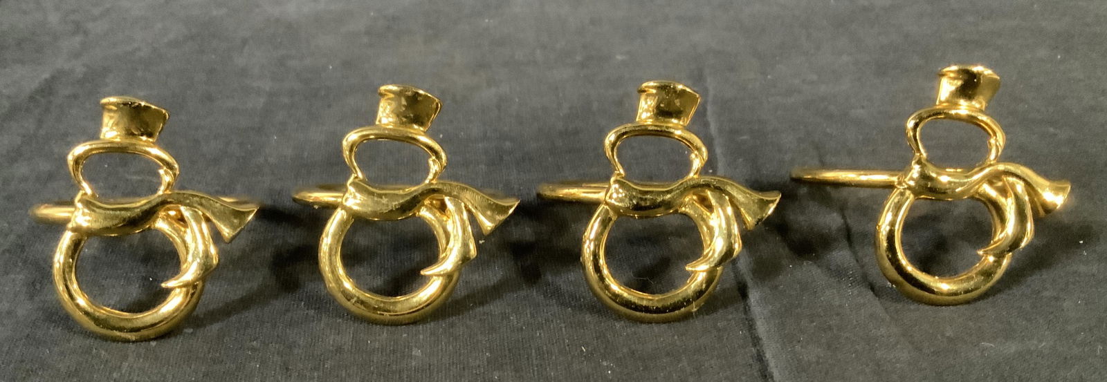 Set 4 Metal Snowman Napkin Holders: Set 4 Metal Snowman Napkin Holders, no apparent inscriptions or stamps, gold toned metal, stylized snowman design, measures 1 5/8 inches in diameter, some surface wear but overall in good condition, S