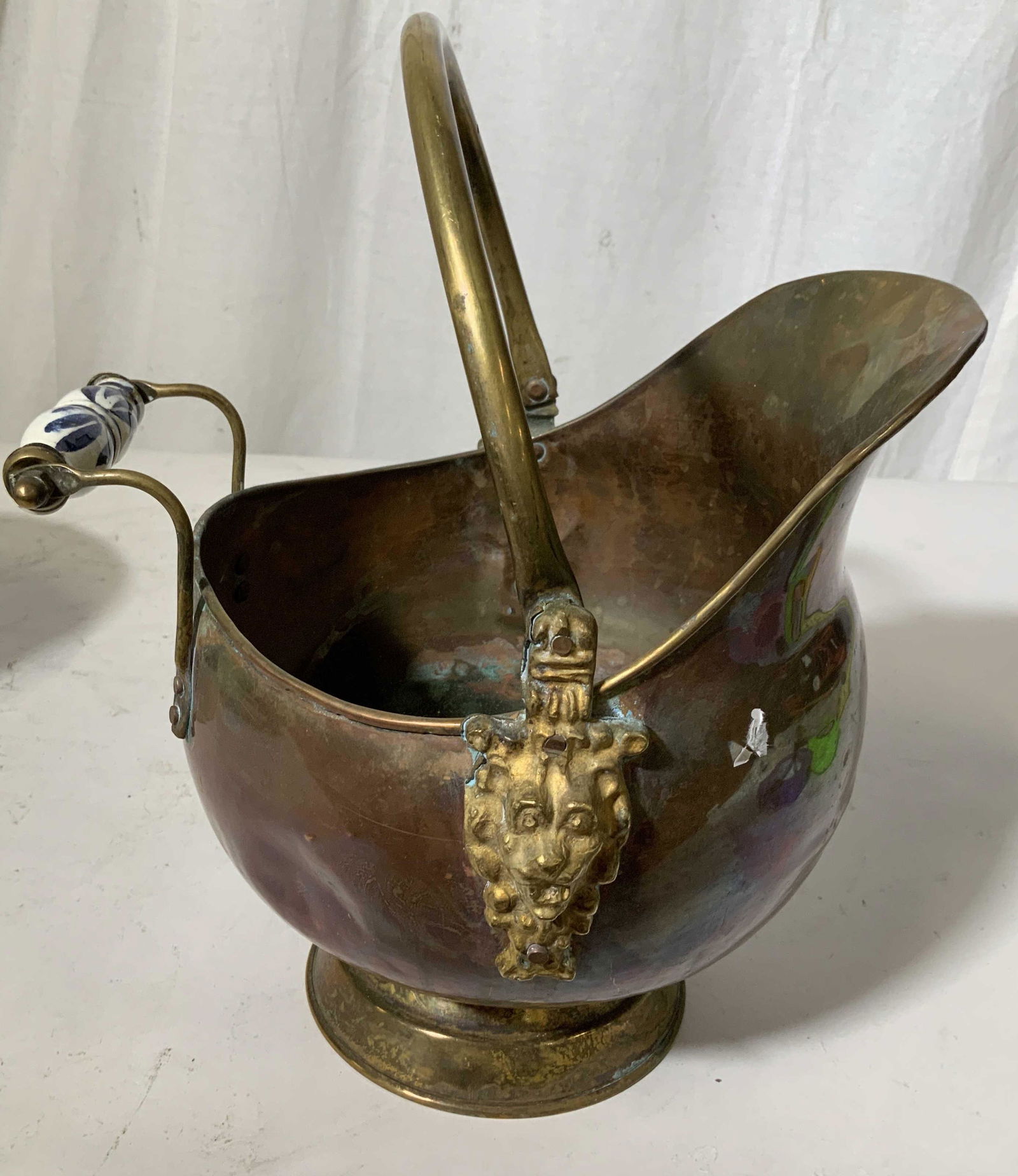 Antique Copper Coal Scuttle Lion Heads: With blue white porcelain carry handles, lion heads, brass pedestal base and handles, measures to handle top app 13 inches length app 11 inches, coal scuttle, log bin, fireplace accessories