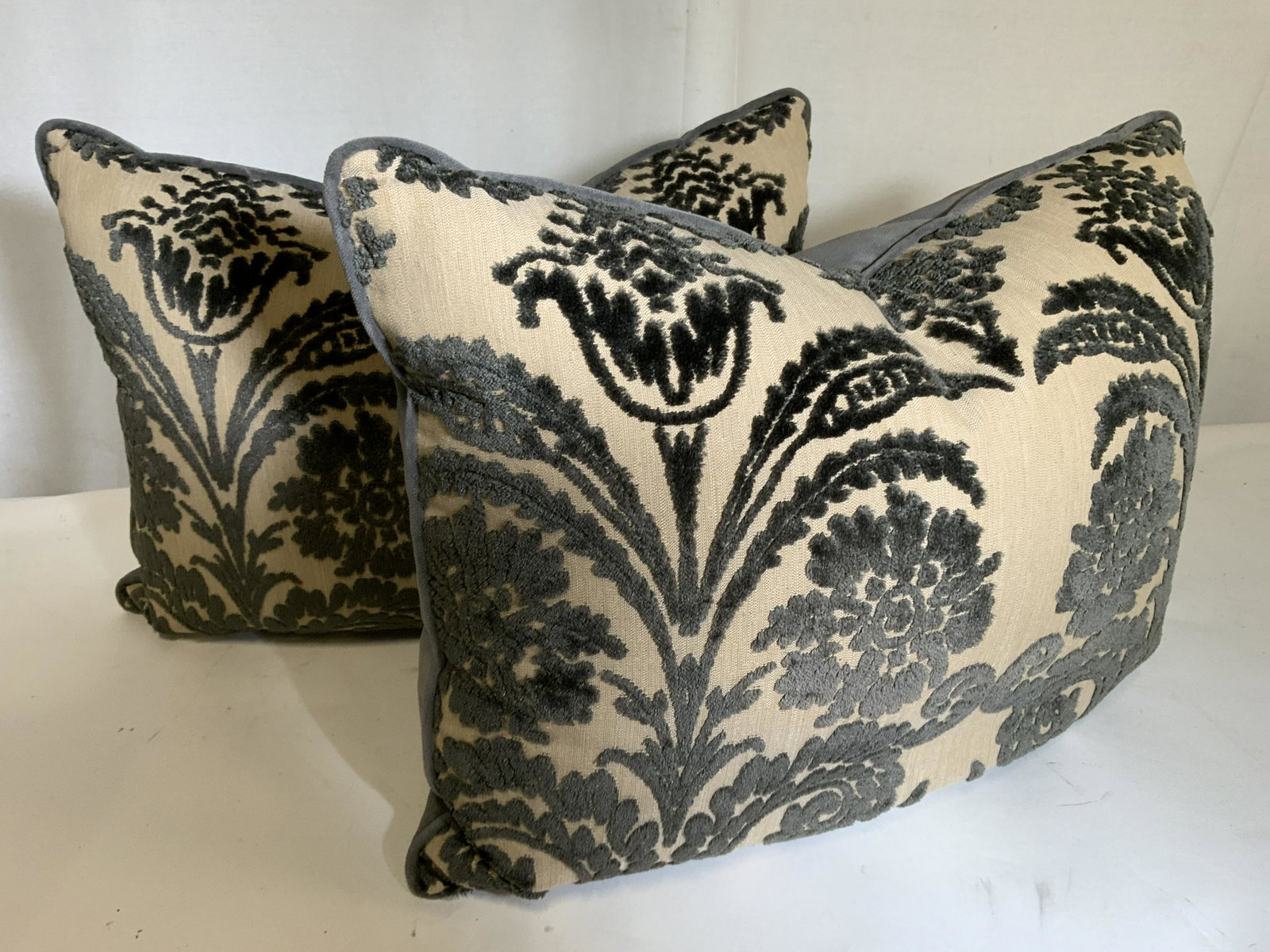 Pr Luxury Grey Tan Velour Down Toss Pillows: Bespoke Deep Grey Velour Pillows with front panel of scrolls and floral design in relief on tan woven fabric. All grey velour piping. Covers are removable, zippered. Inserts are down feather 25 x 21 i