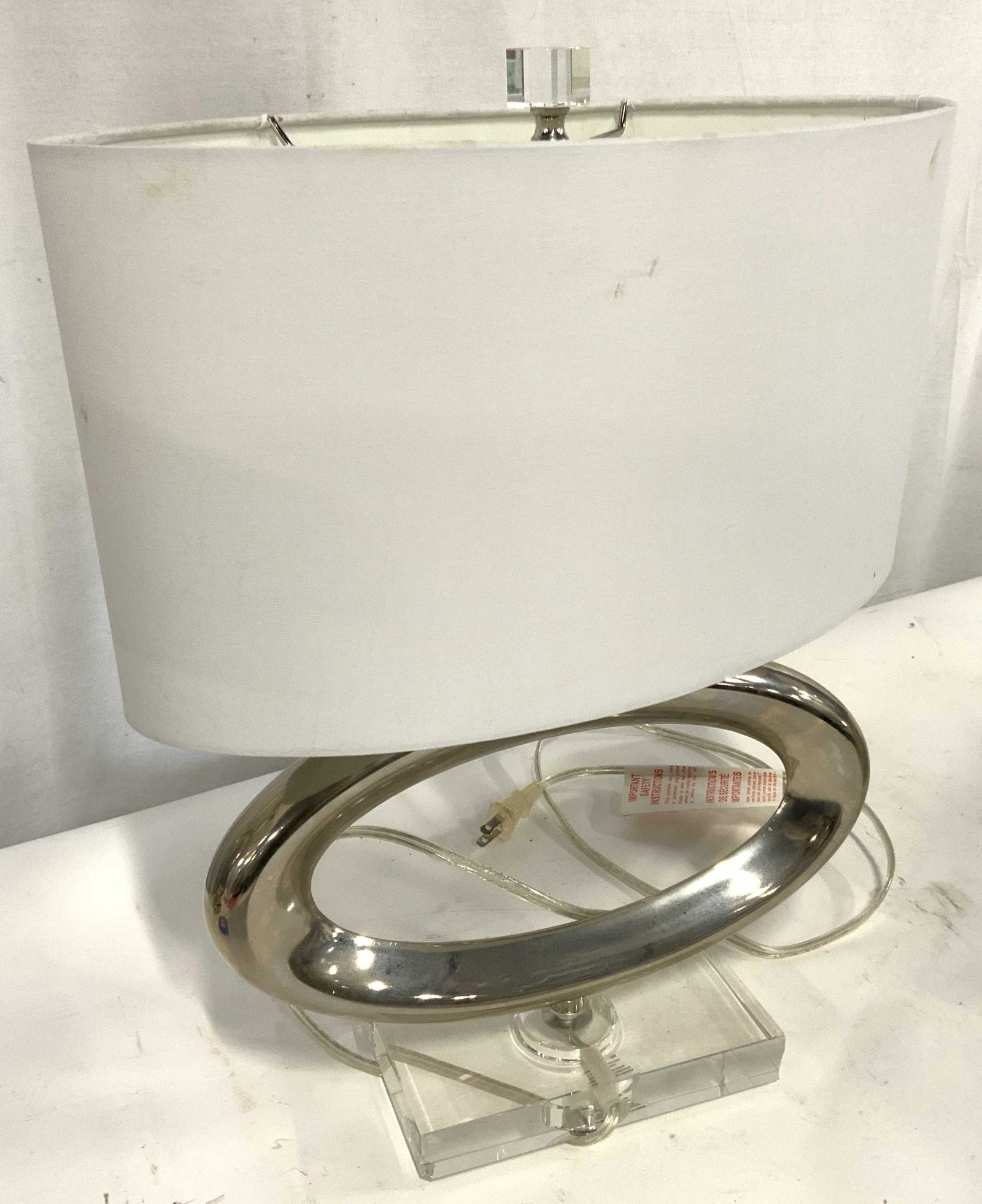 MODERNIST CHROME & LUCITE Table Lamp w/ Shade: A tabletop pendant lane that has an open oblong chrome shape with rectangular lucite base and cubical lucite finial. White linen pendant shade. Modernist design. 3 way light switch. Long clear cord in